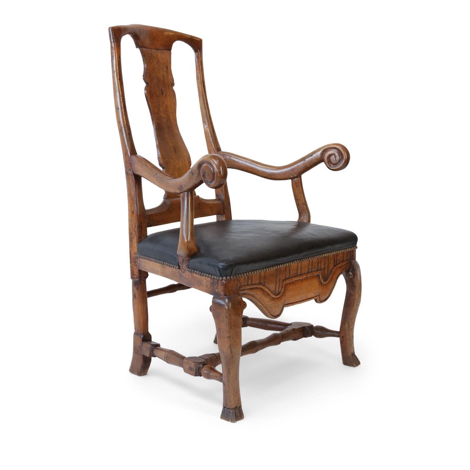 Large Baroque Swedish armchair well-carved in generous proportions, dating circa 1710-1730. Features a curved splat back, cabriole legs, Braganza feet and hand carved stretchers (not turned), seat covered in later black leather. Uneven lines and