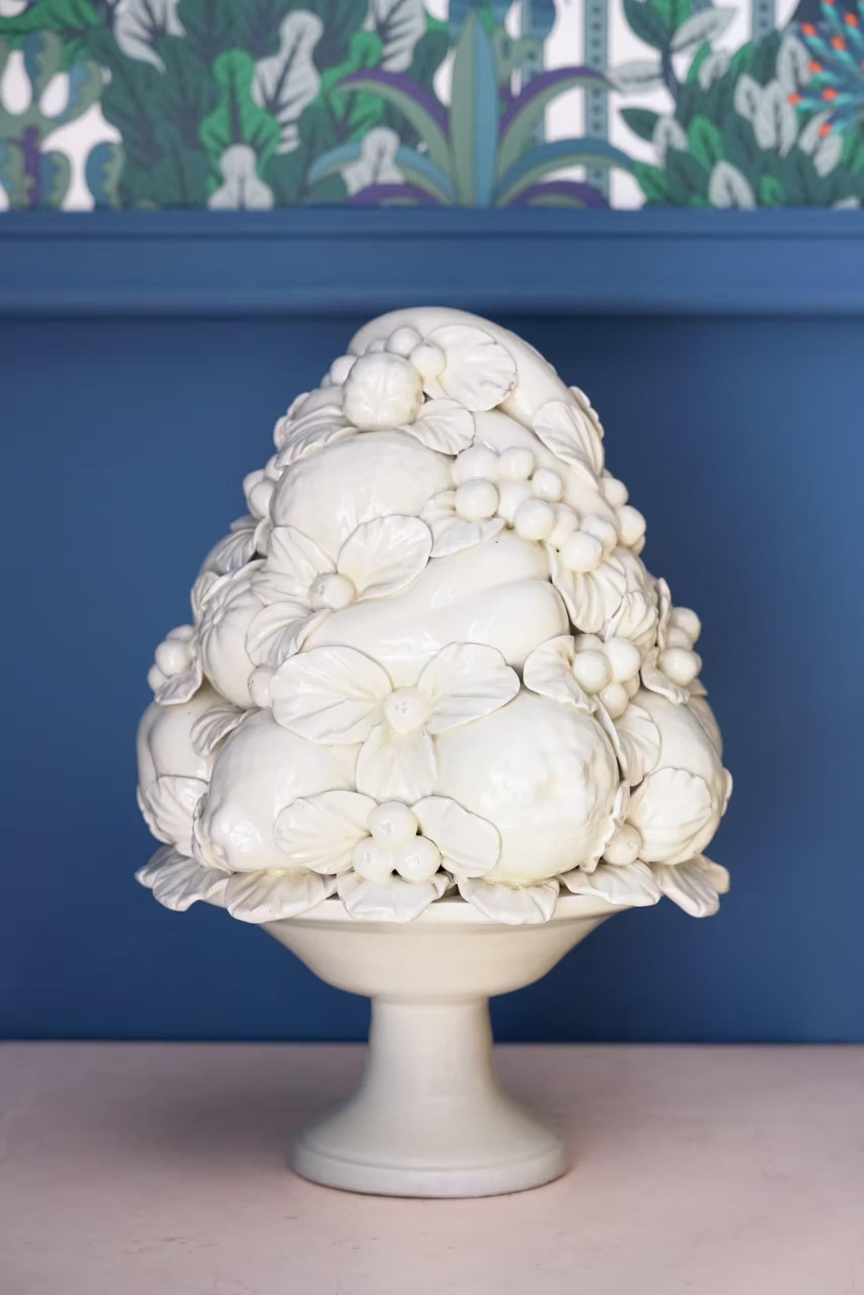 Italienischer Tischaufsatz aus Keramik, weiß/cremefarben glasiert, mit einem Relief aus verschiedenen Früchten auf einem Unterteil in Form einer erhöhten ovalen Schale. Italien, 20. Jahrhundert.