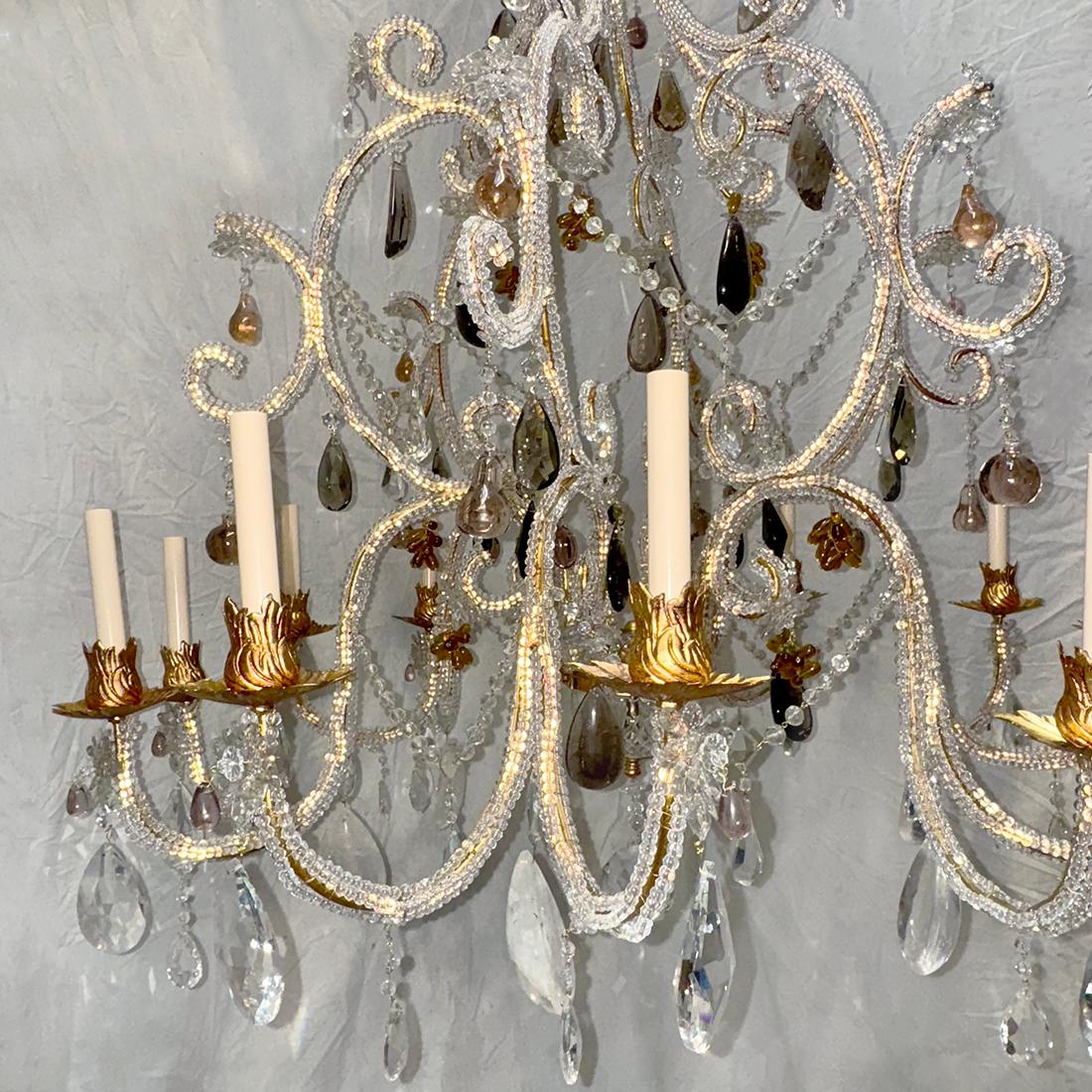 A circa 1950's  French gilt metal chandelier with 12 lights, beaded body with crystal pendants and rock crystals.

Measurements:
Minimum Drop: 56