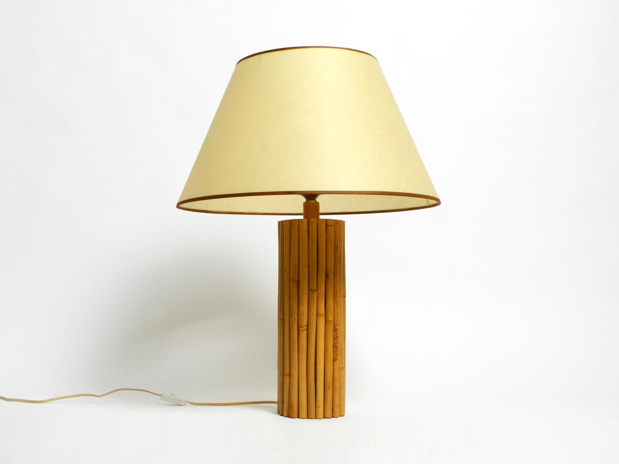 Large 1970s bamboo table lamp with a large paper shade.
Beautiful design from the 1960s. Made in Italy.
Base is made entirely of individual bamboo canes.
Very good vintage condition, with no damage. Great natural color, not faded.
The large shade is