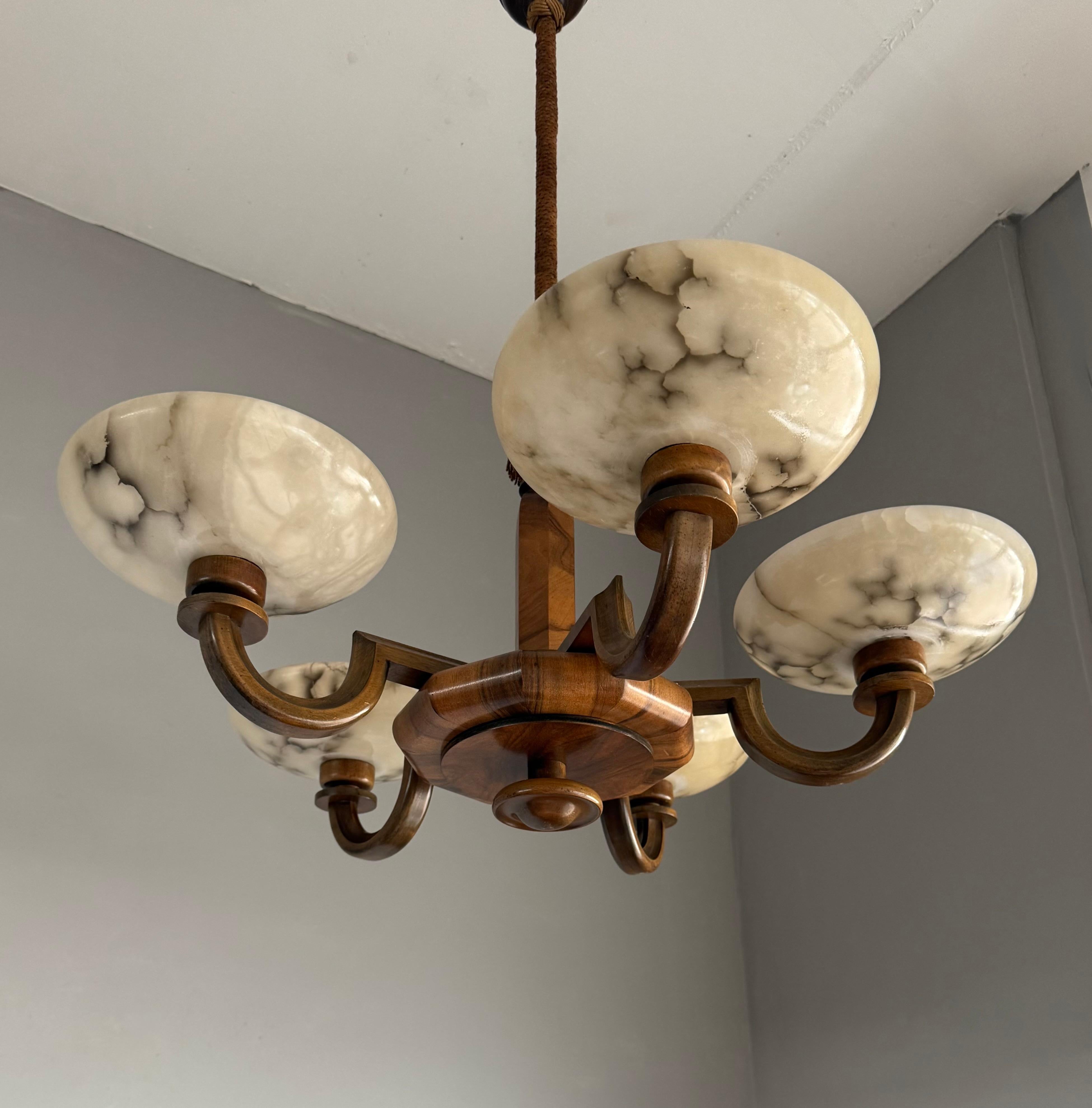 Striking and exclusive 1920s solid wooden and alabaster light fixture for the perfect atmosphere.

If you are looking for a remarkable light fixture to grace your living space then this antique Art Deco chandelier from the earliest years of the 20th