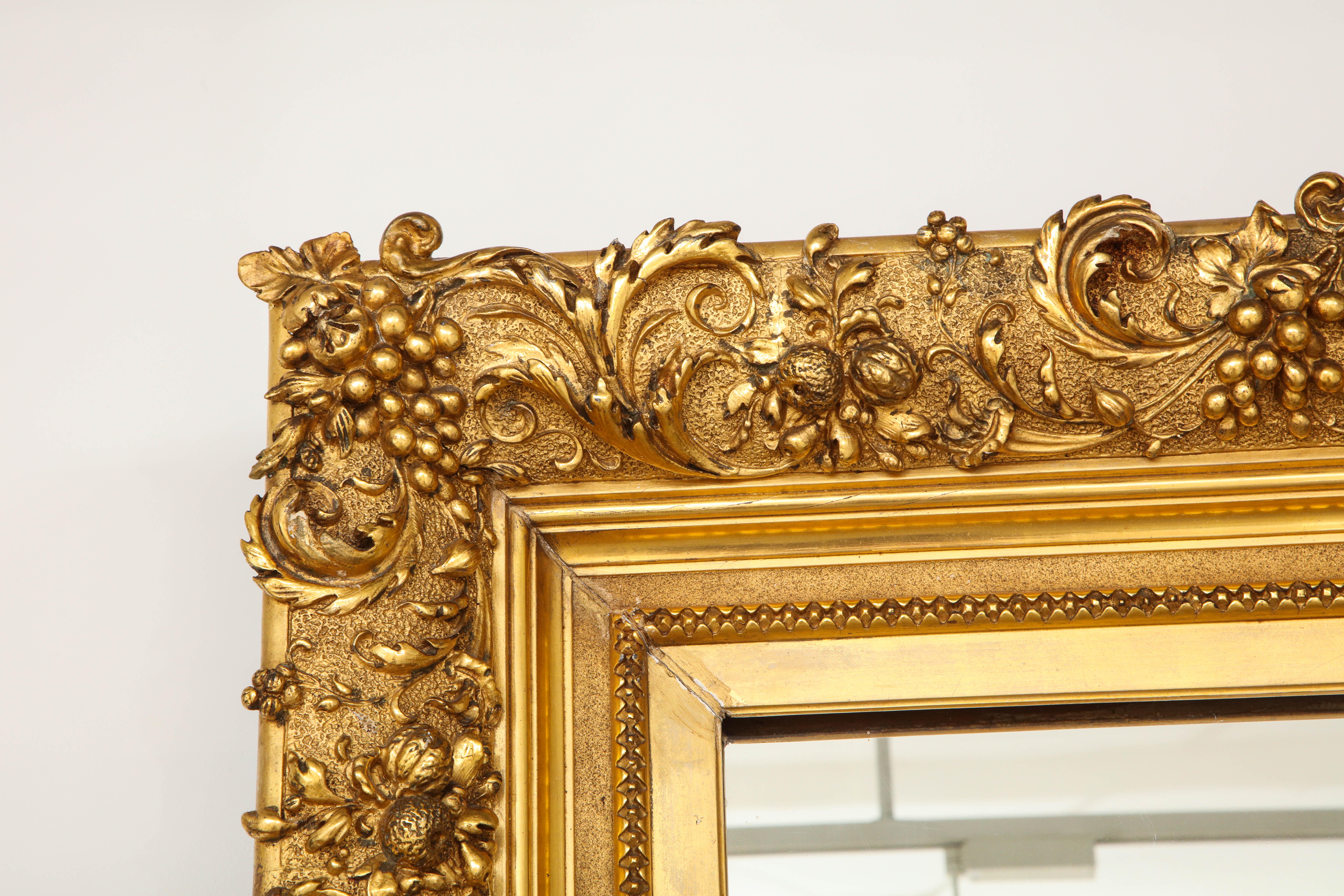 Large giltwood mirror, with carved grape leaves and clusters.