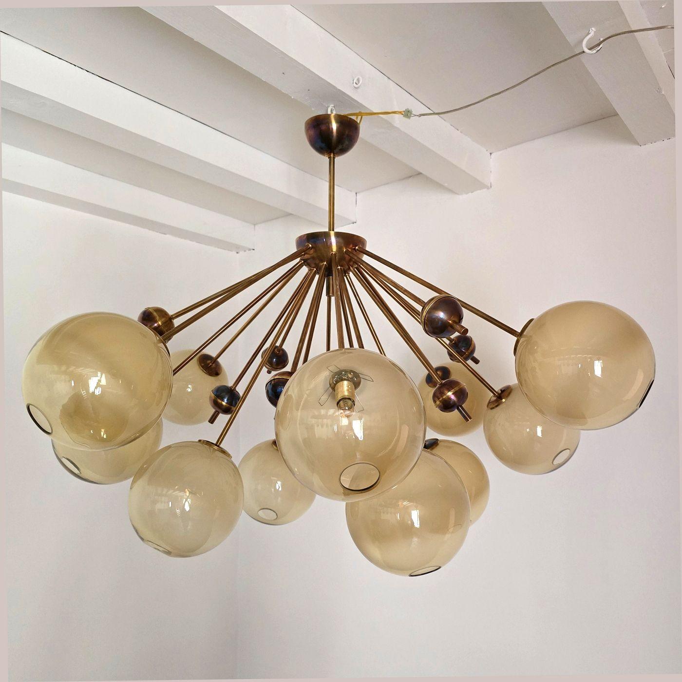 Grand lustre en verre demi Sputnik, style Stilnovo Italie années 1990.
Le lustre de style moderne du milieu du siècle est composé de montures en laiton et de douze globes en verre de Murano.
Chaque globe emboîte une ampoule. Le verre de Murano est