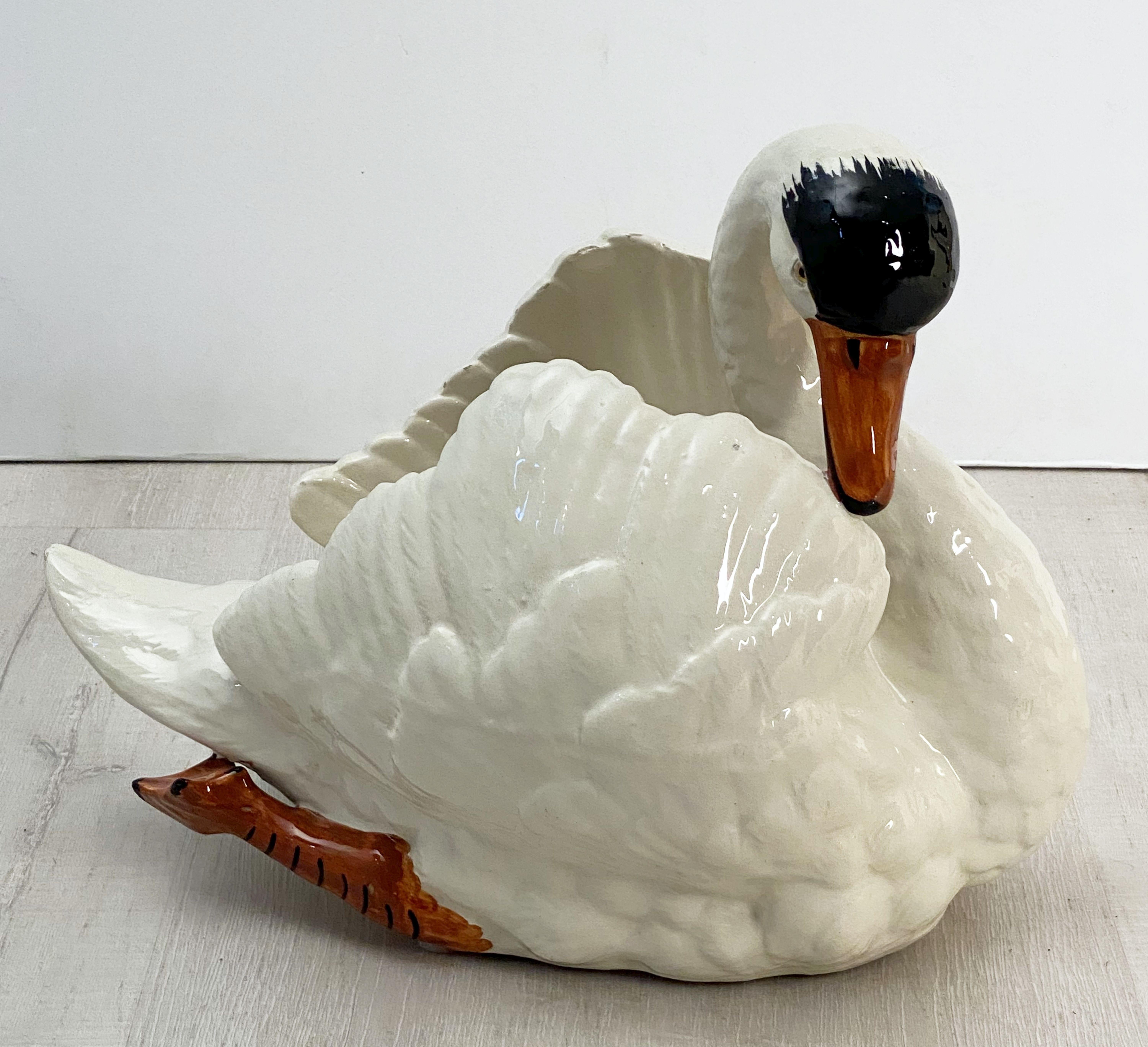 A fine Belgian large figurative swan planter or vase featuring an elegantly modeled swan in white with hand painted accents.
