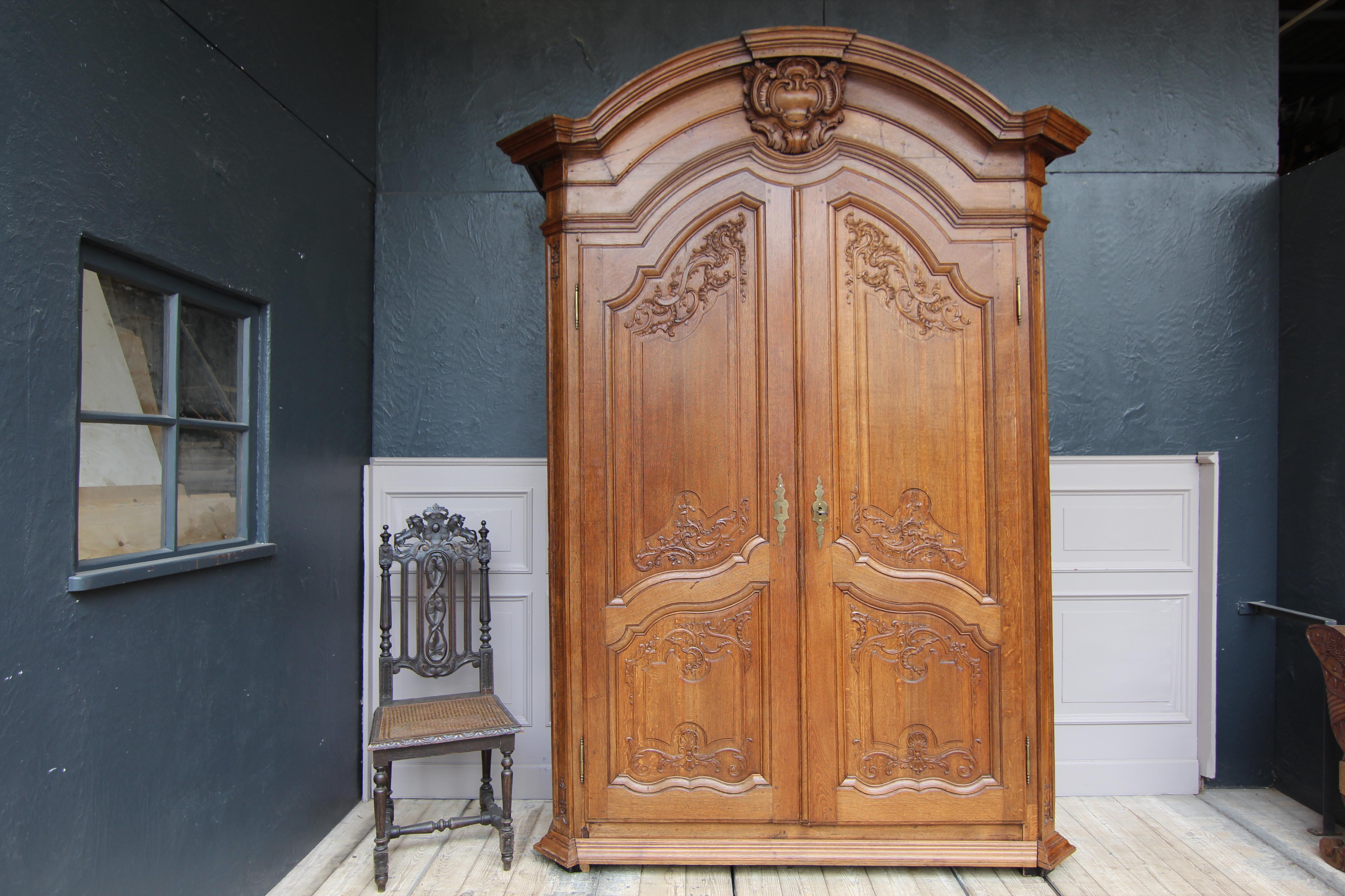 Cabinet in the Régence style from the late 18th or early 19th century. Presumably from the Belgian-French border region of Mons.

Made of solid oak and finely carved.

High, laterally coffered two-door body with bevelled corners and a curved,