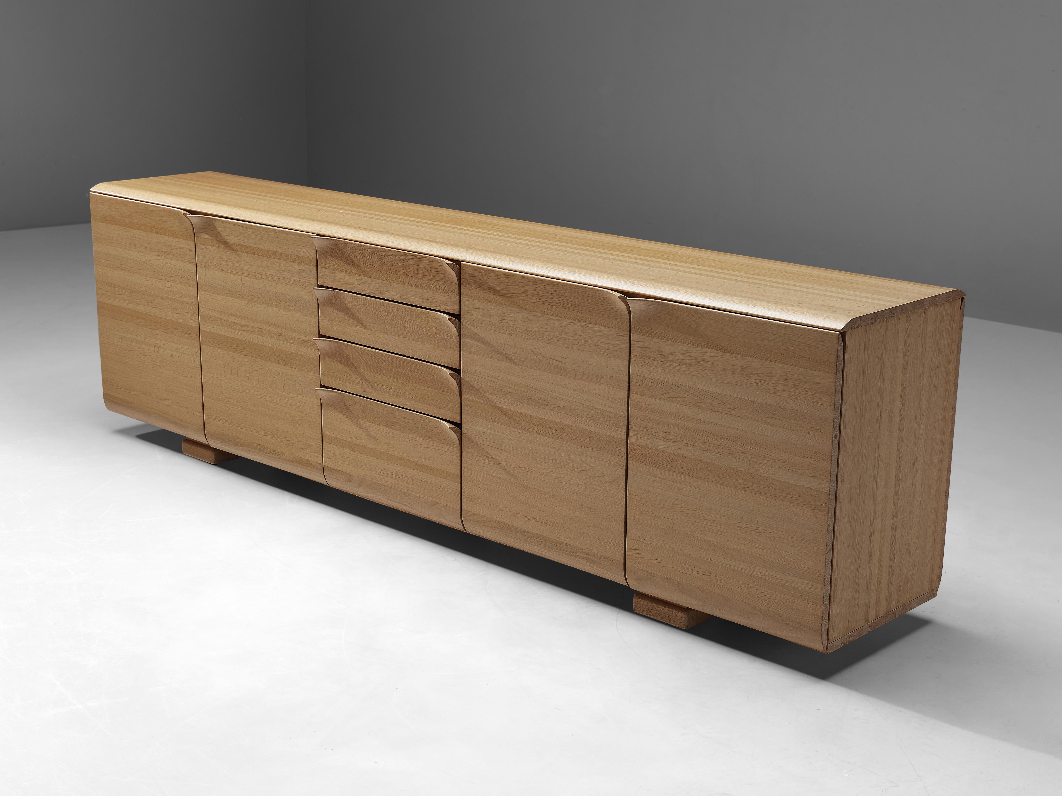 Bob Van Den Berghe for Van Den Berghe Pauvers, sideboard, oak, Belgium, 1970s.

This Minimalist Belgian credenza features striking handles. The doors flow over in the handles, which bent like a page of paper. The credenza offers plenty of storage