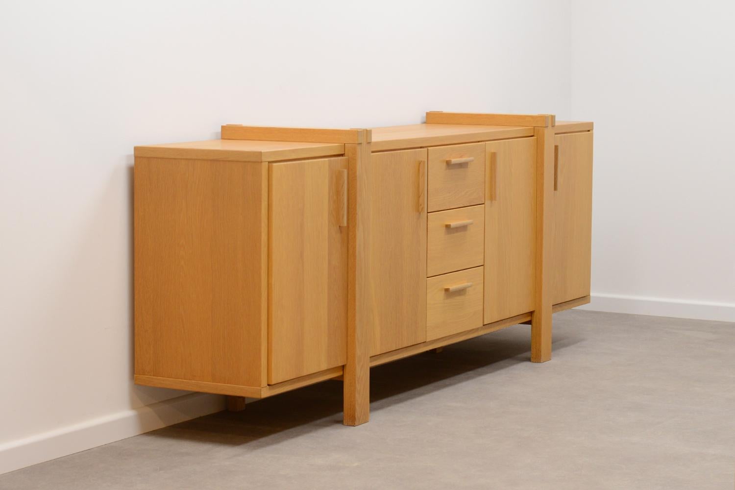 Large Belgium oak sideboard. Mostly made of solid oak. 3 drawers and 4 doors. Behind every door are modular shelfs. In very good vintage condition.