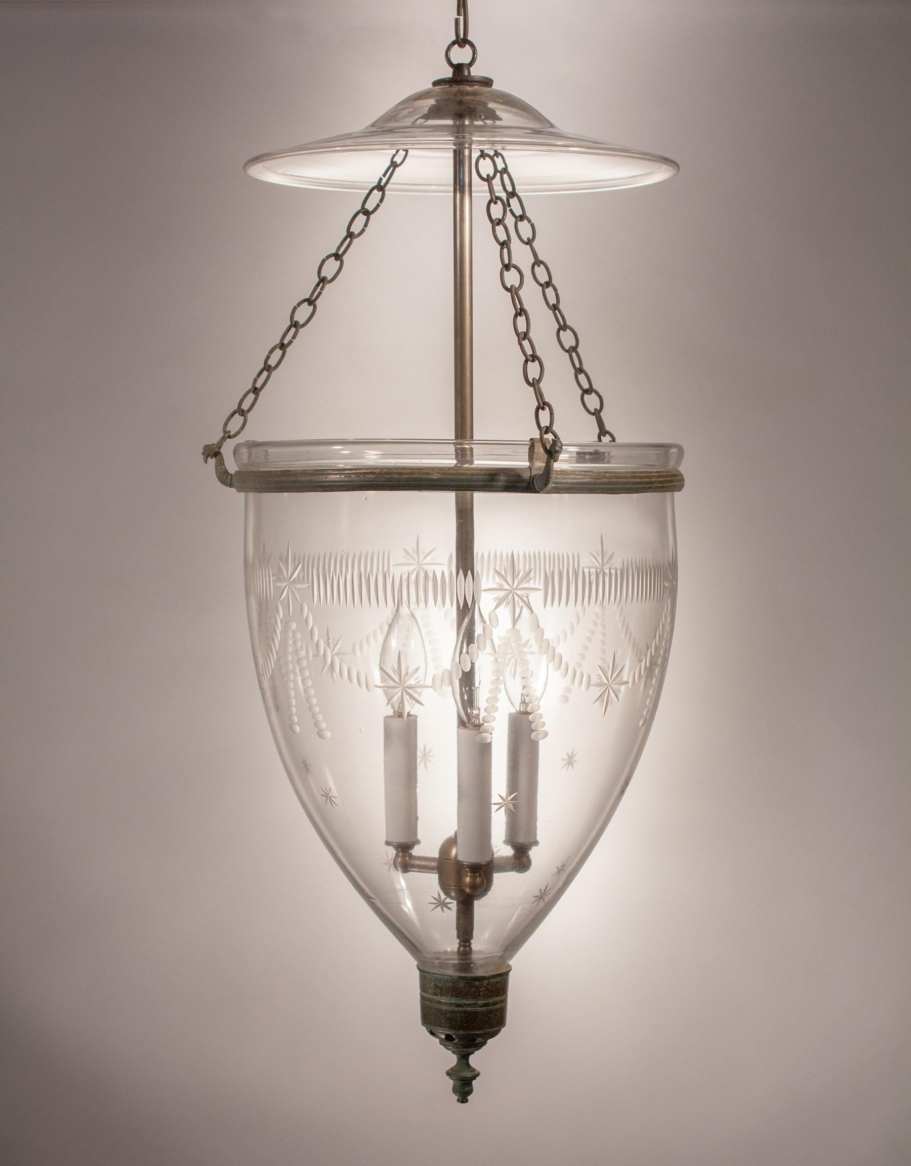 The quintessential antique hall lantern, this larger-sized bell jar lantern features superb form and a finely etched Federal-style motif in its handblown glass. The lantern has all-original fittings, including rolled brass band, brass finial and
