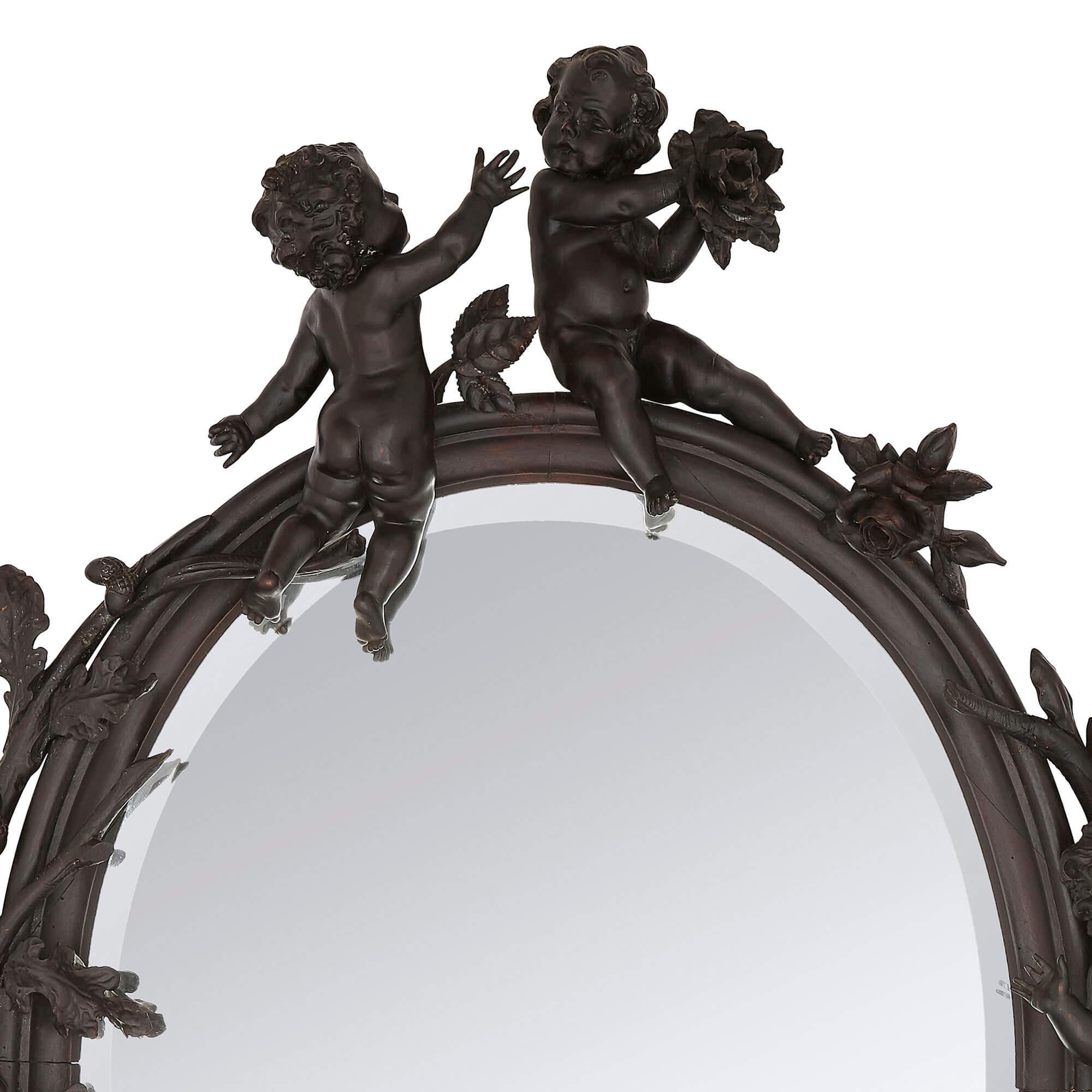 Large Belle Époque period carved wood wall mirror
French, late 19th Century
Measures: Height 166cm, width 122cm, depth 22cm

This fine Belle Epoque mirror is crafted from ebonised wood in a decadent manner. The oval mirror features an ornate