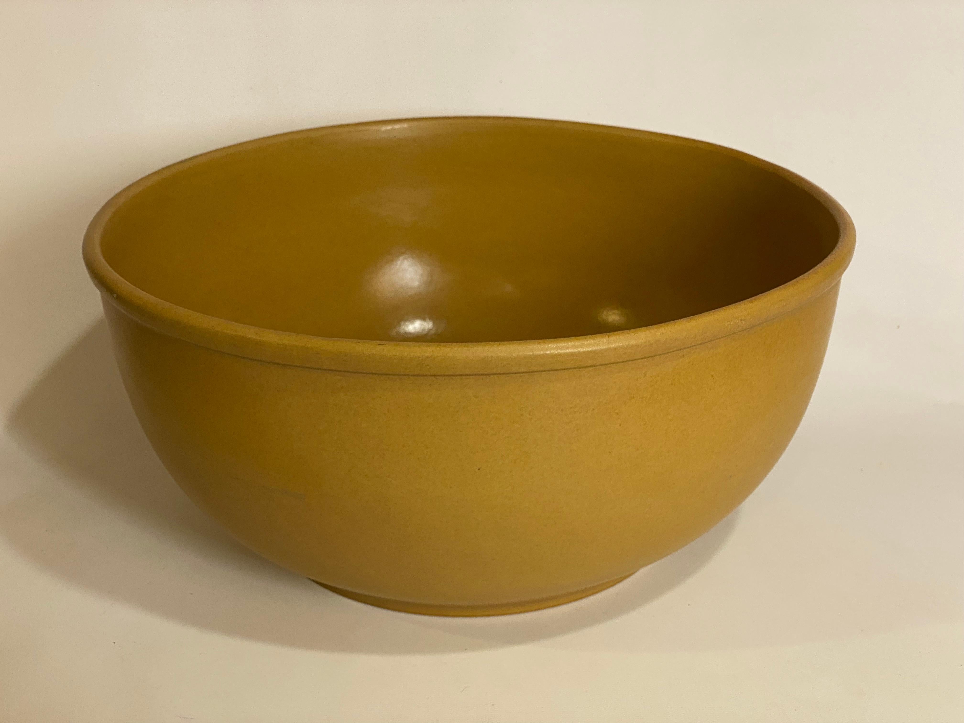 A large Bennington Potters, Bennington, Vermont Tawny Mustard glazed bowl. Signed on the bottom, Bennington Potter, Bennington, Vermont, dg, *2180. David Gil design. Large and impressive bowl. Circa 1970. A gorgeous golden centerpiece for fruit or