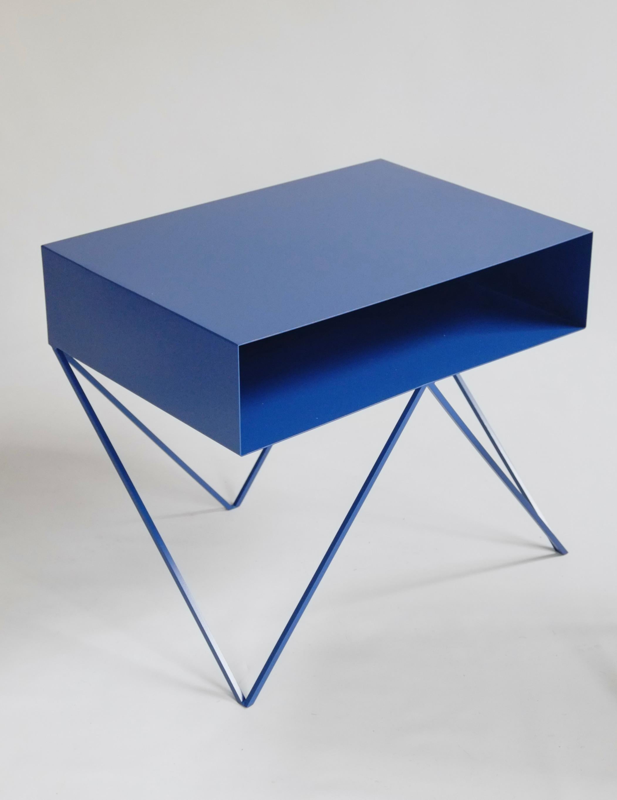 A bespoke pair (size customisable) of elegant Blueberry blue steel Robot bedside tables. The Robot side table features an open shelf on zig zag legs. A wide, low elegant design made of solid steel, powder-coated in Blueberry. The clean lines look