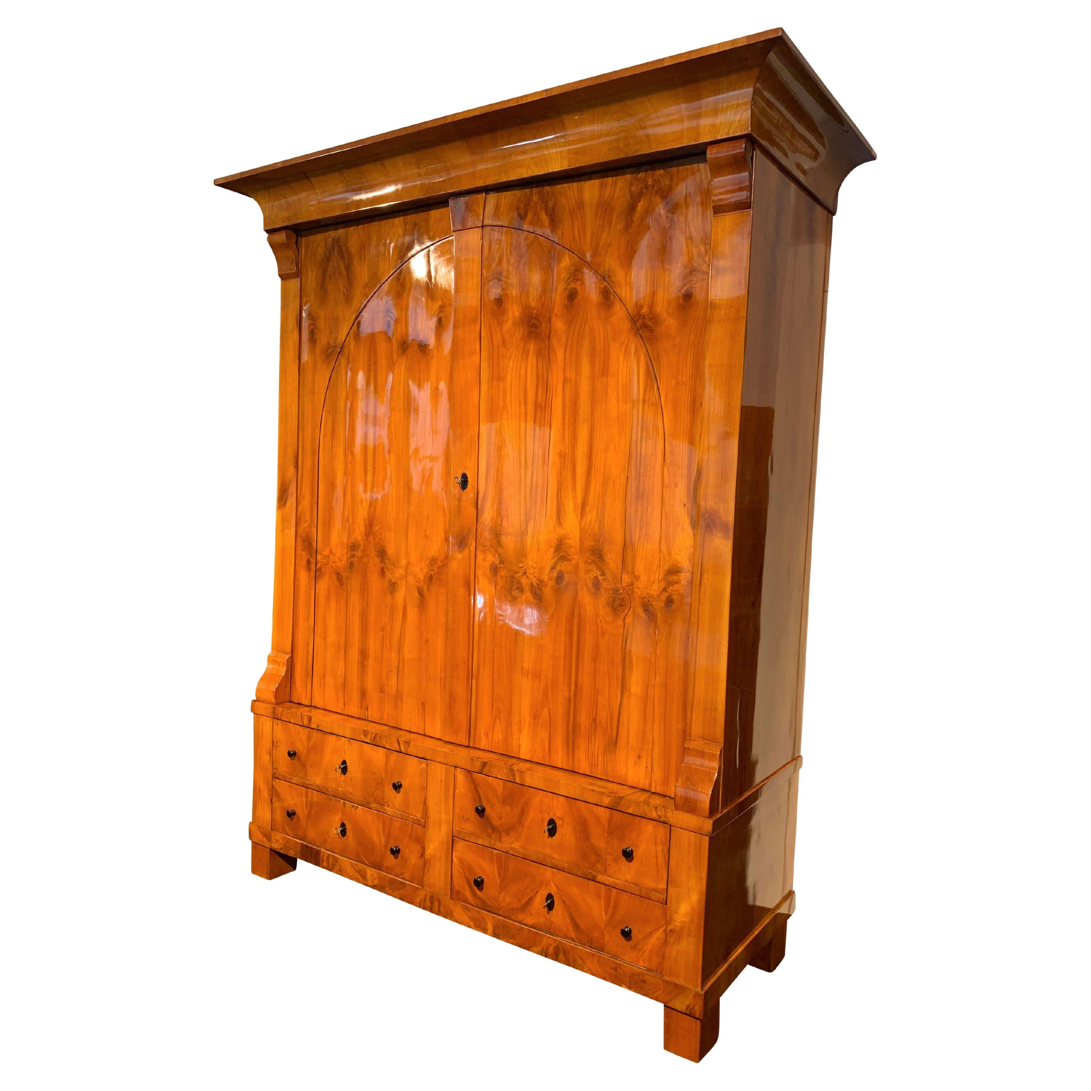 Großer, originaler Biedermeier Schrank in Kirschbaumfurnier, aus dem Rheinland, Deutschland um 1820.

Wunderschönes, helles Kirschbaumfurnier, handpoliert mit Schellack (French Polish).
Schönes großes und geschwungenes Gesims aus Kirschbaumfurnier,