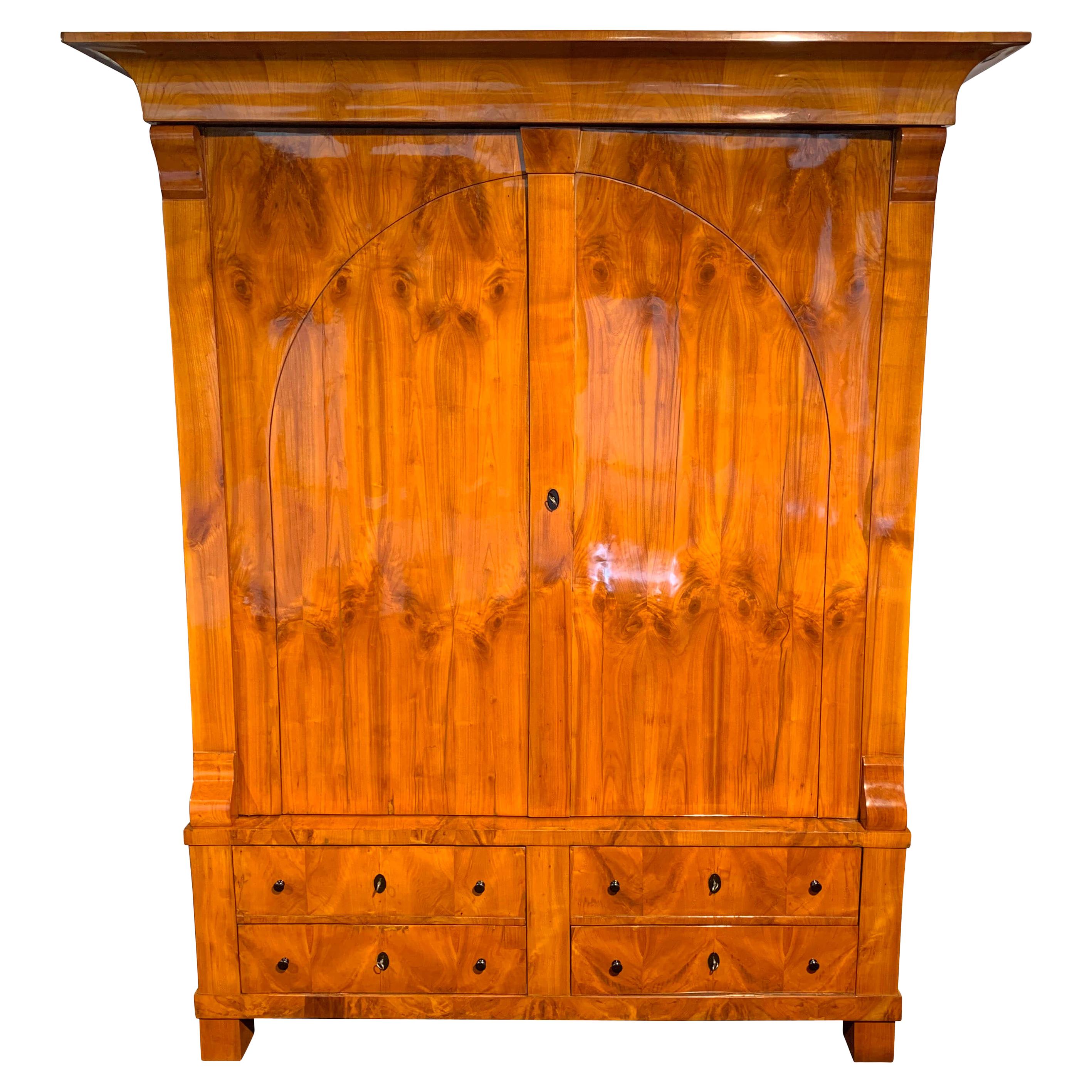 Large, original Biedermeier Armoire in cherry veneer, from Rhineland, Germany circa 1820.


Wonderful, bright cherry veneer, hand-polished with shellac (French Polish).
Beautiful big and curved cherry veneered cornice, classicist arch on the doors