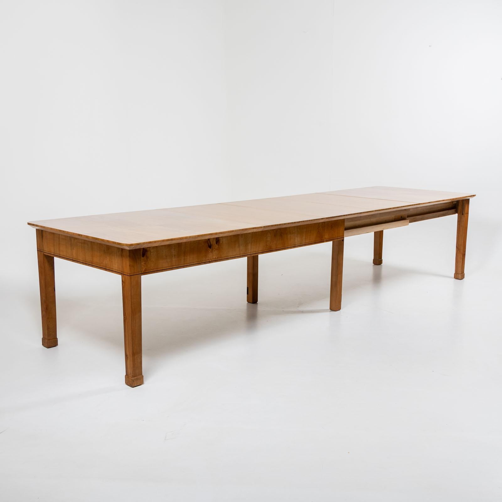 Large Biedermeier dining table with three additional extension leaves (62 cm each) on square legs and a straight frame. The table is made of ash wood and has been polished by hand. The table can be extended to a total length of 380 cm. Two fold-out