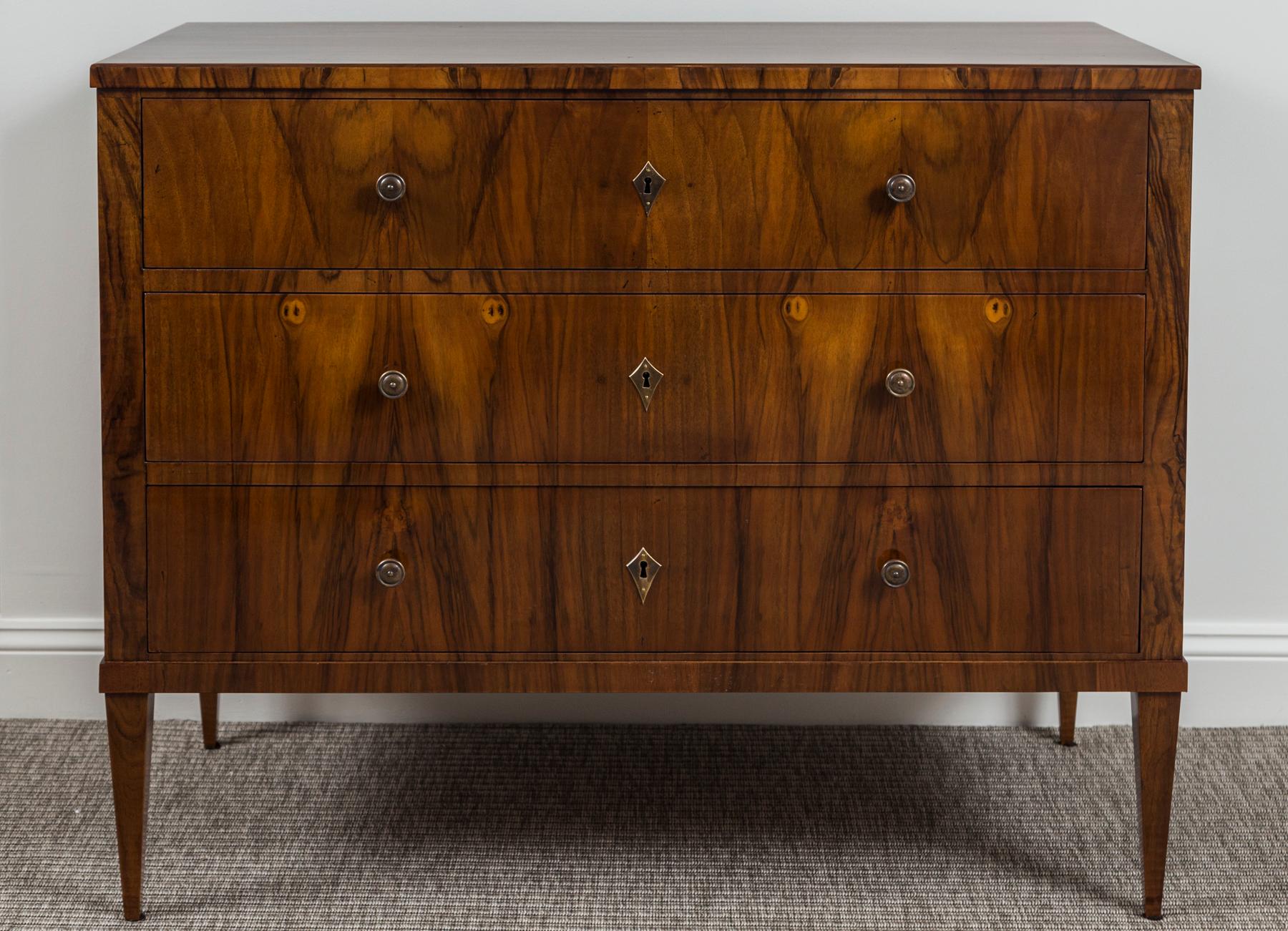 La cassapanca Biedermeier, impiallacciata in noce scuro su pino, è composta da tre lunghi cassetti che poggiano su alte gambe diritte e affusolate. Ogni cassetto contiene una chiave funzionante.

Datazione:1860-1880ca

Origine: Germania

Condizioni: