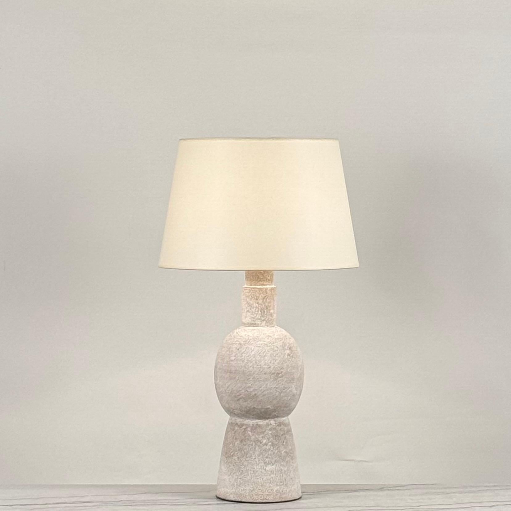 Grande lampe en grès blanc 'Bilboquet' par Design Frères.
Fabriqué en France par nos artisans qualifiés.
Câblée avec des pièces homologuées UL, un interrupteur à 3 voies (marche, demi marche, arrêt), un cordon torsadé, et équipée d'un abat-jour