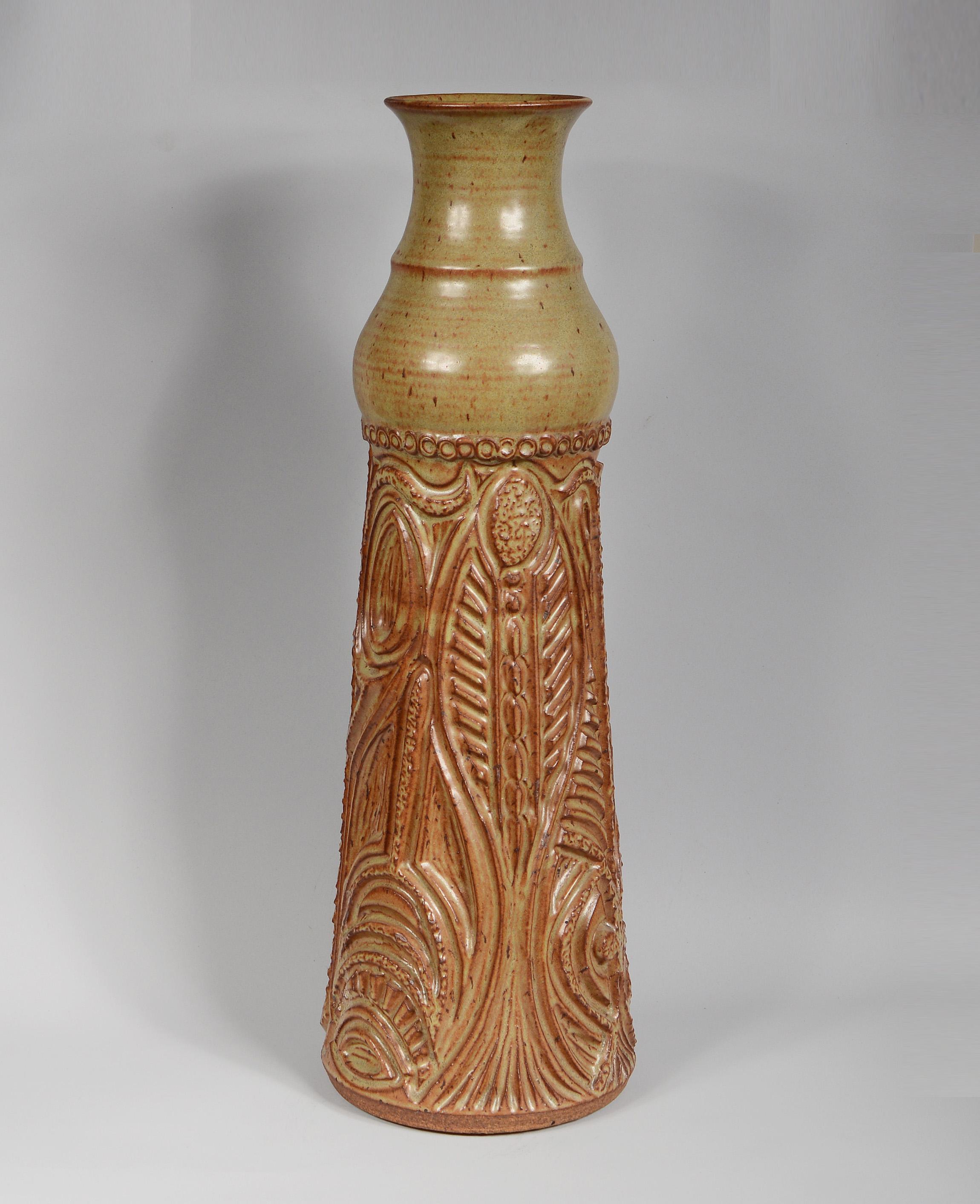 Tall pottery vase by Northern California potters Bill and June Vaughn. The vase is intricately and deeply carved. June would do the carving and Bill the throwing.