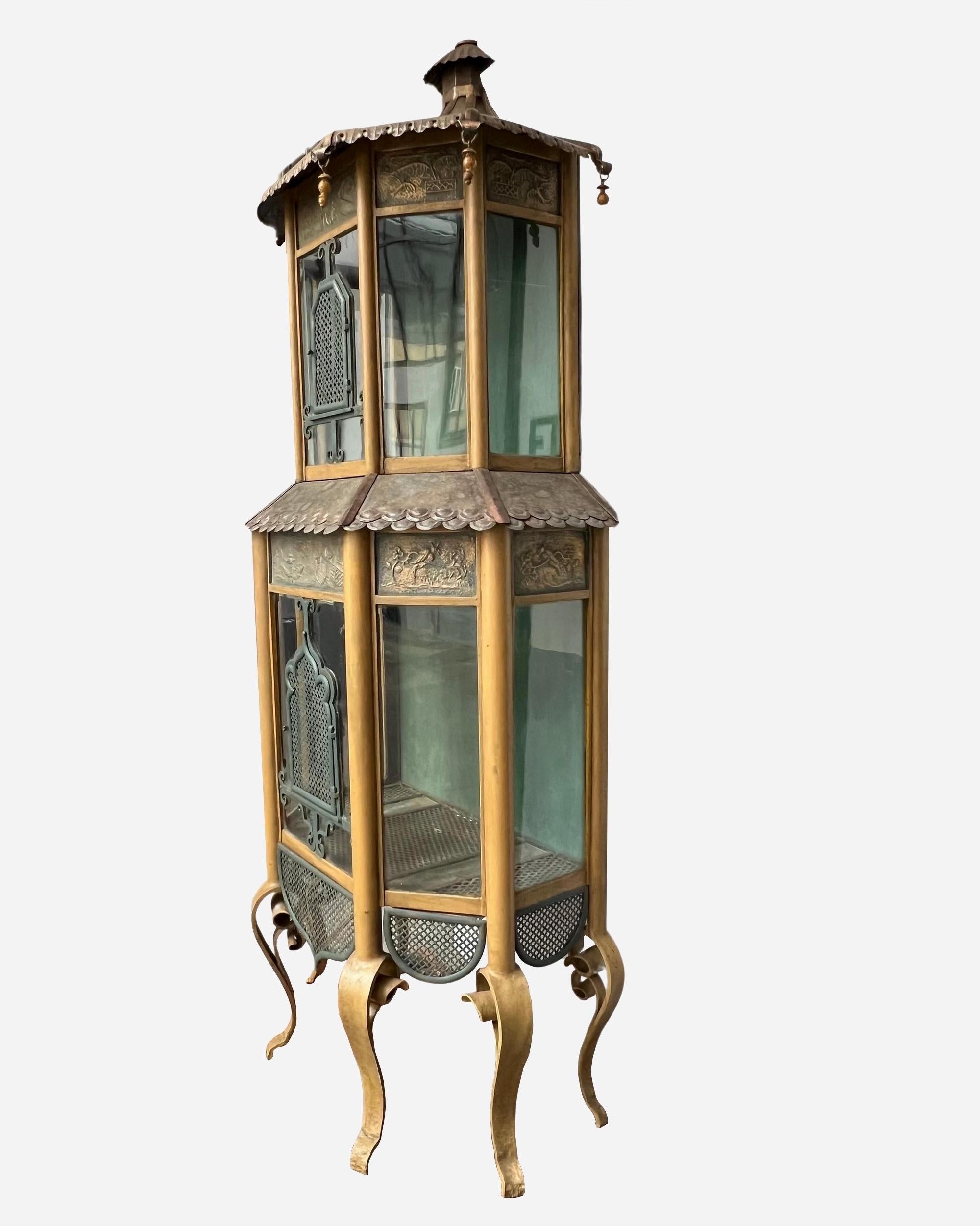 Importante cage à oiseaux de style japonais simulant une pagode à deux niveaux.
La structure de la cage est en fer forgé peint et patiné, supportant des cloisons en verre transparent. Le fond est en bois peint.
Les toits sont en cuivre patiné et en