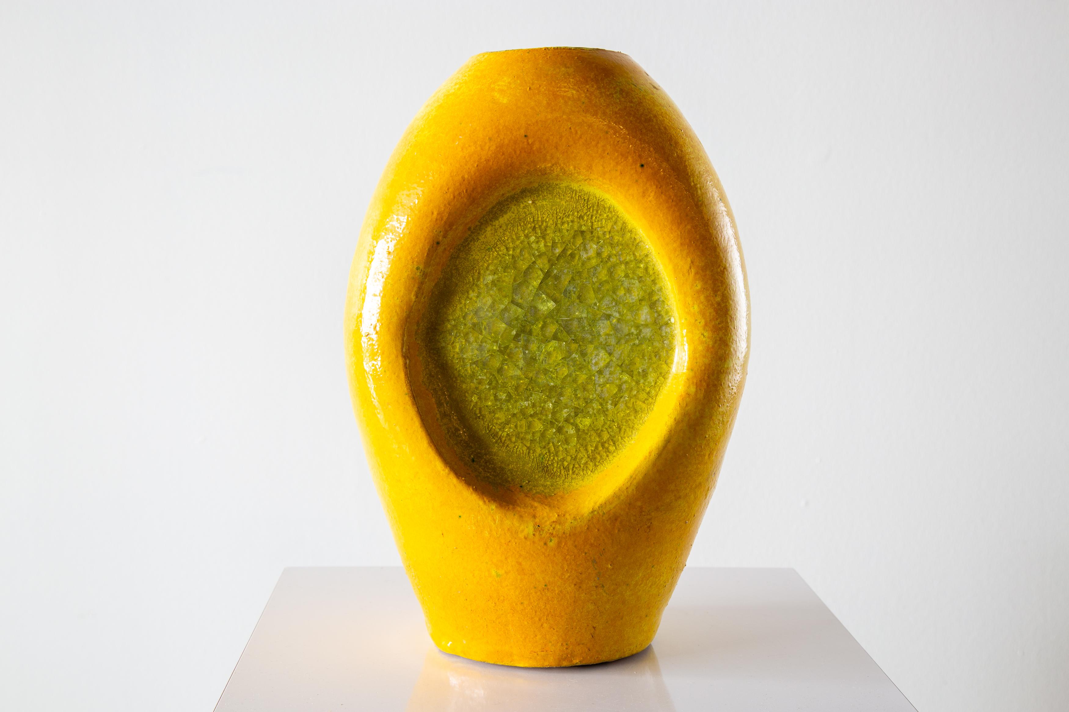 A 1950s large Bitossi fritte vase. Melted green and fused glass sits crackeled inside a dimpled yellow glazed stone form.  Large scale at 13.5” high, and 9” Wide. this is a statement piece. A great pop of yellow and green. Heavy weight. A fine