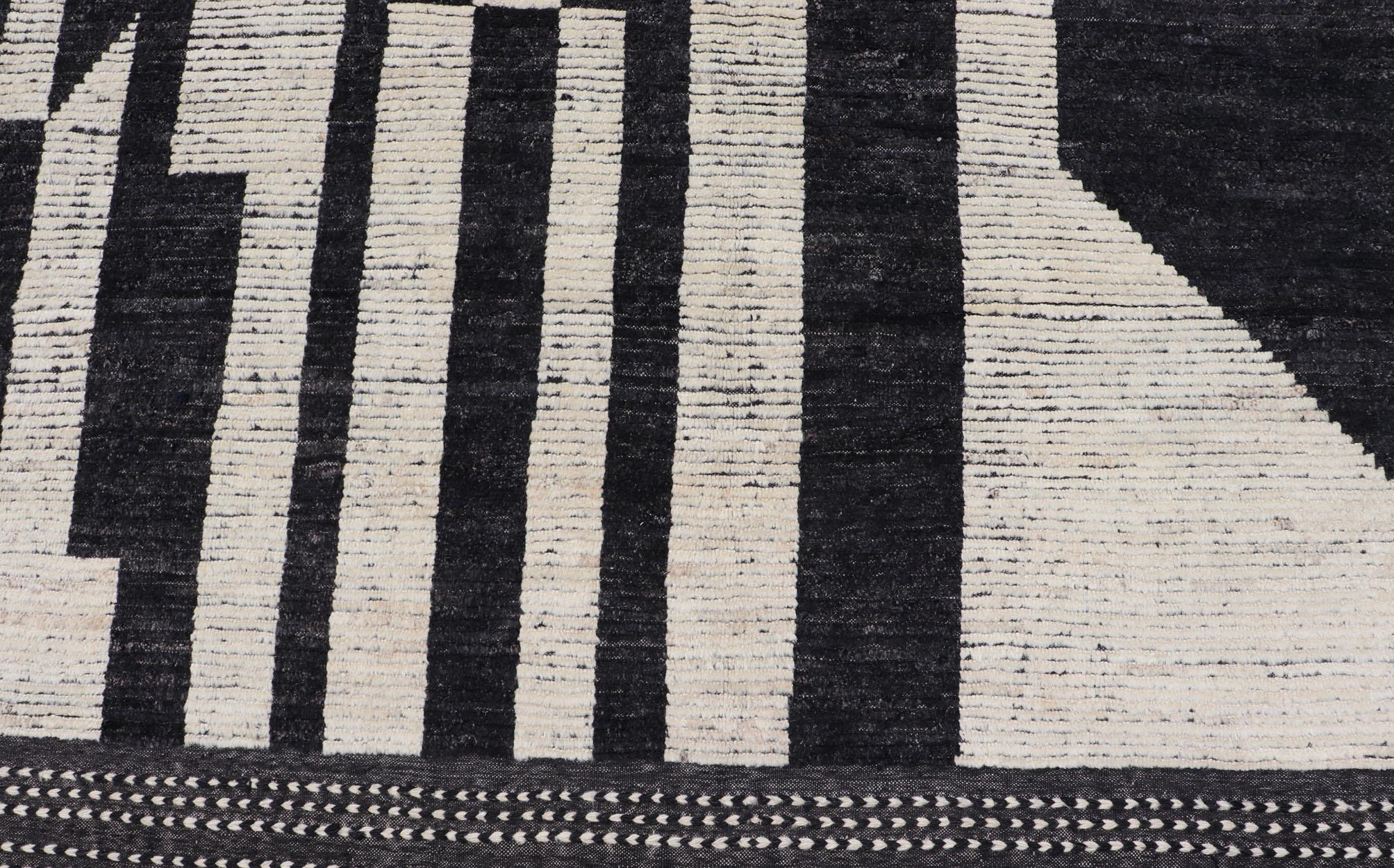 This oversized modern casual was hand-knotted in Afghanistan. The field portrays an ivory background disrupted by flashes of ebony abstractions. The small simple border has a crafty ivory embroidery with black.  

Keivan Woven Arts; rug AFG-43436  