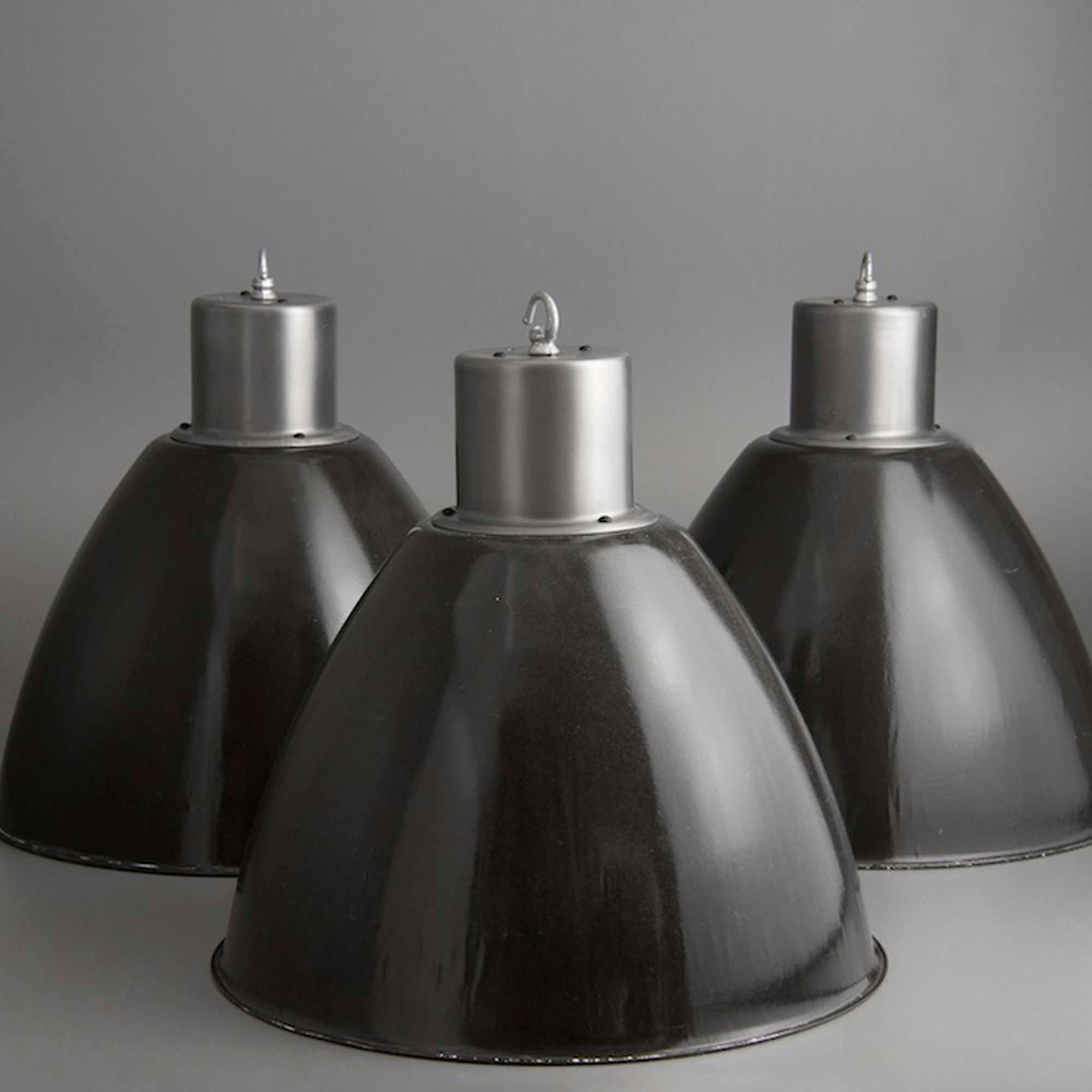 Substantial, extra-large enamelled industrial pendant lights featuring their original brushed and lacquered steel galleries. Salvaged from a factory on the border of the former Czech Republic and Slovakia, these imposing fixtures are authentic