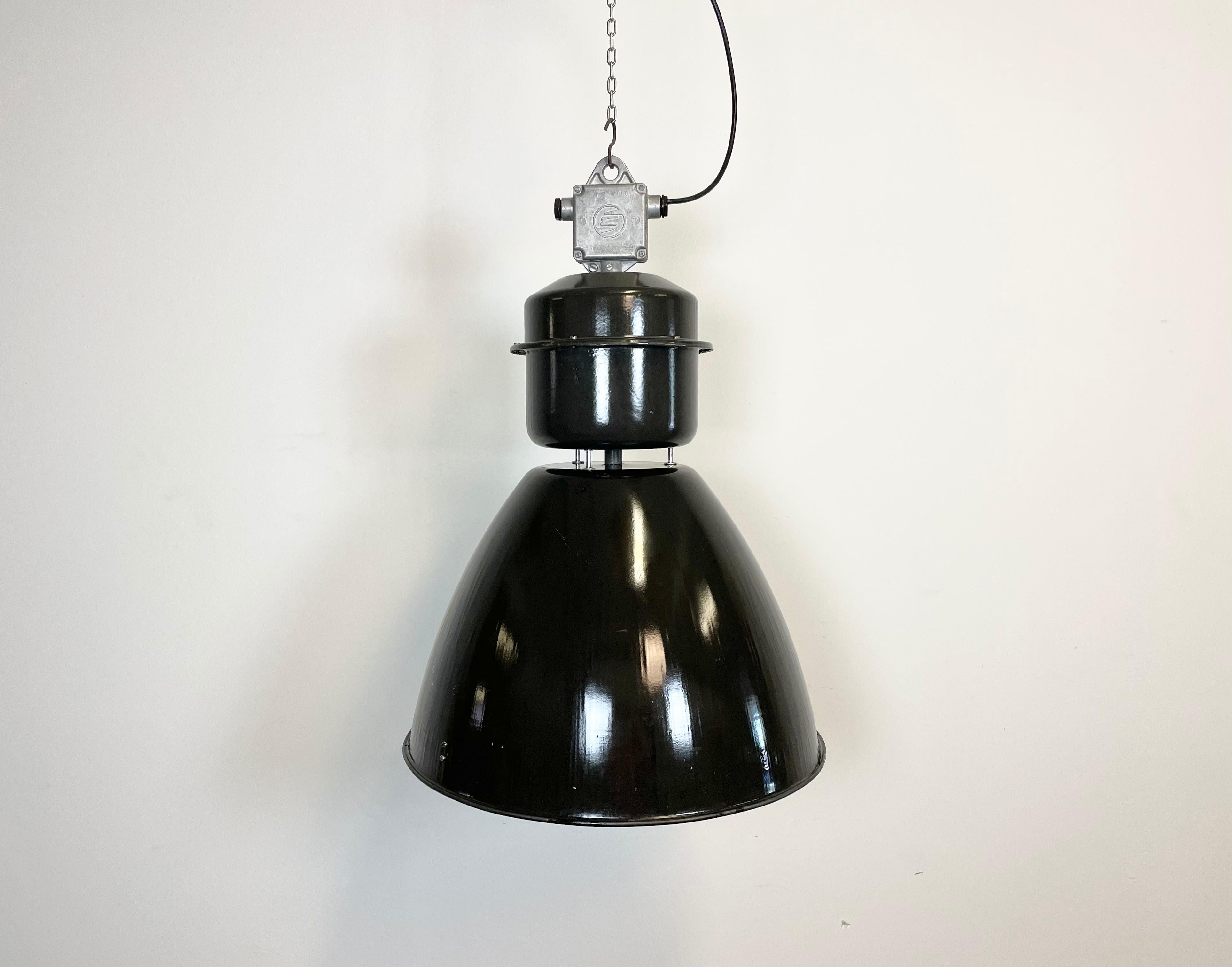 This black industrial pendant light was designed in the 1960s and produced by Elektrosvit in the former Czechoslovakia. It features a cast aluminium top, a black enamel exterior and a white enamel interior.
New porcelain socket for E 27 lightbulbs