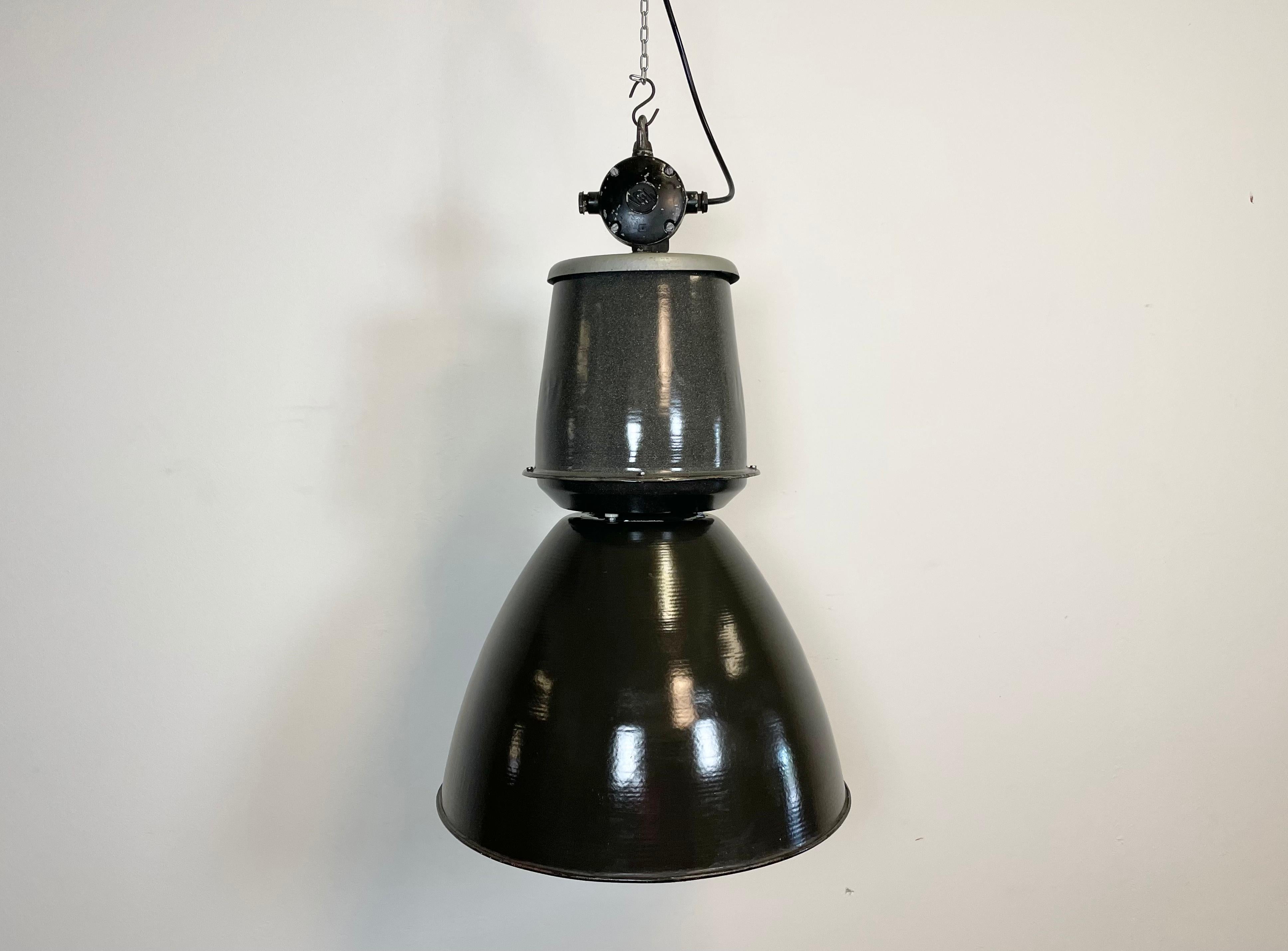 This black industrial pendant light was designed in the 1960s and produced by Elektrosvit in the former Czechoslovakia. It features a cast aluminium top, a black enamel exterior and white enamel interior.
New porcelain socket for E 27 lightbulbs