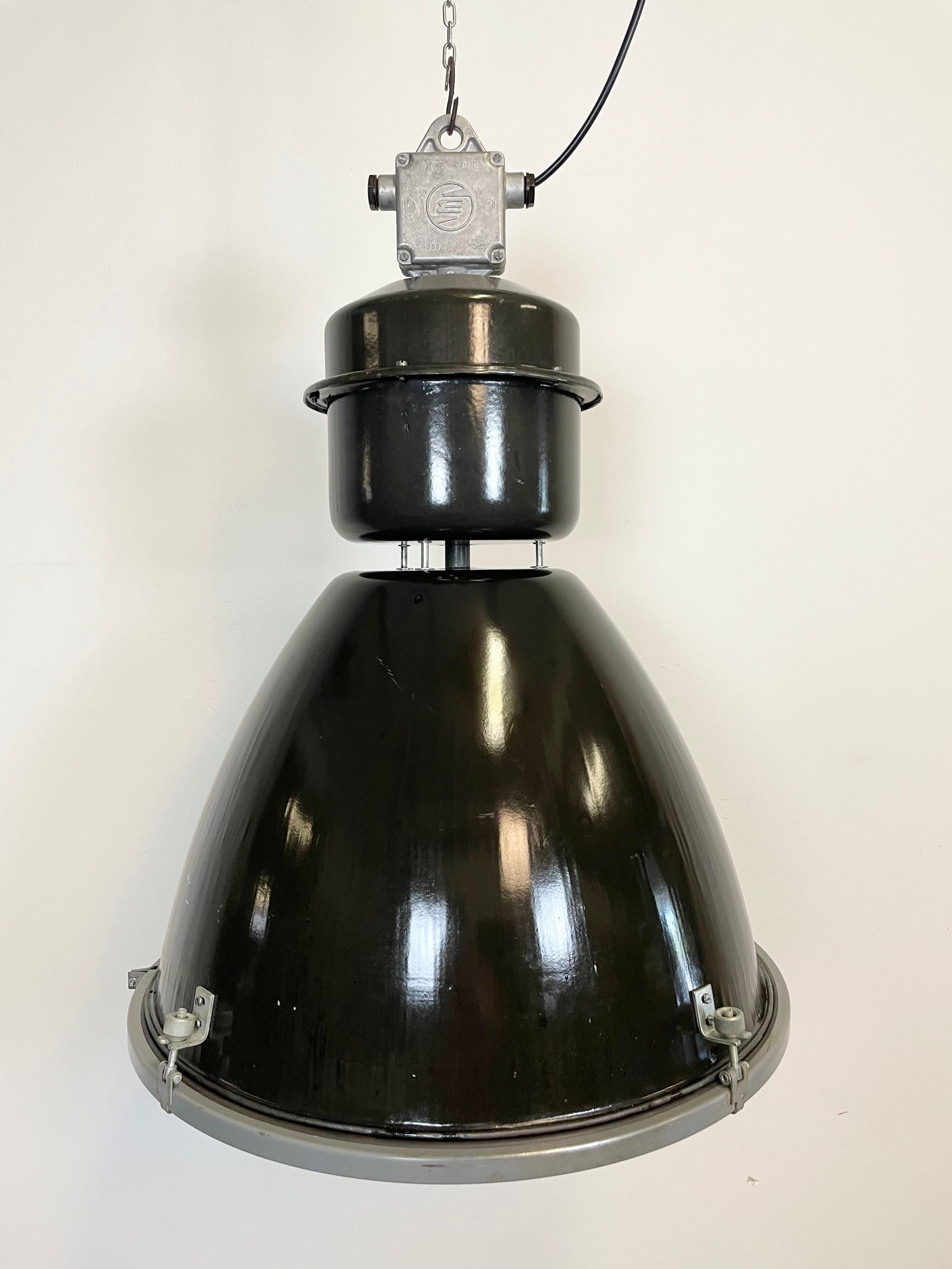 This black industrial pendant light was designed in the 1960s and produced by Elektrosvit in the former Czechoslovakia. It features a cast aluminium top, a black enamel exterior, a white enamel interior and clear glass cover.
New porcelain socket