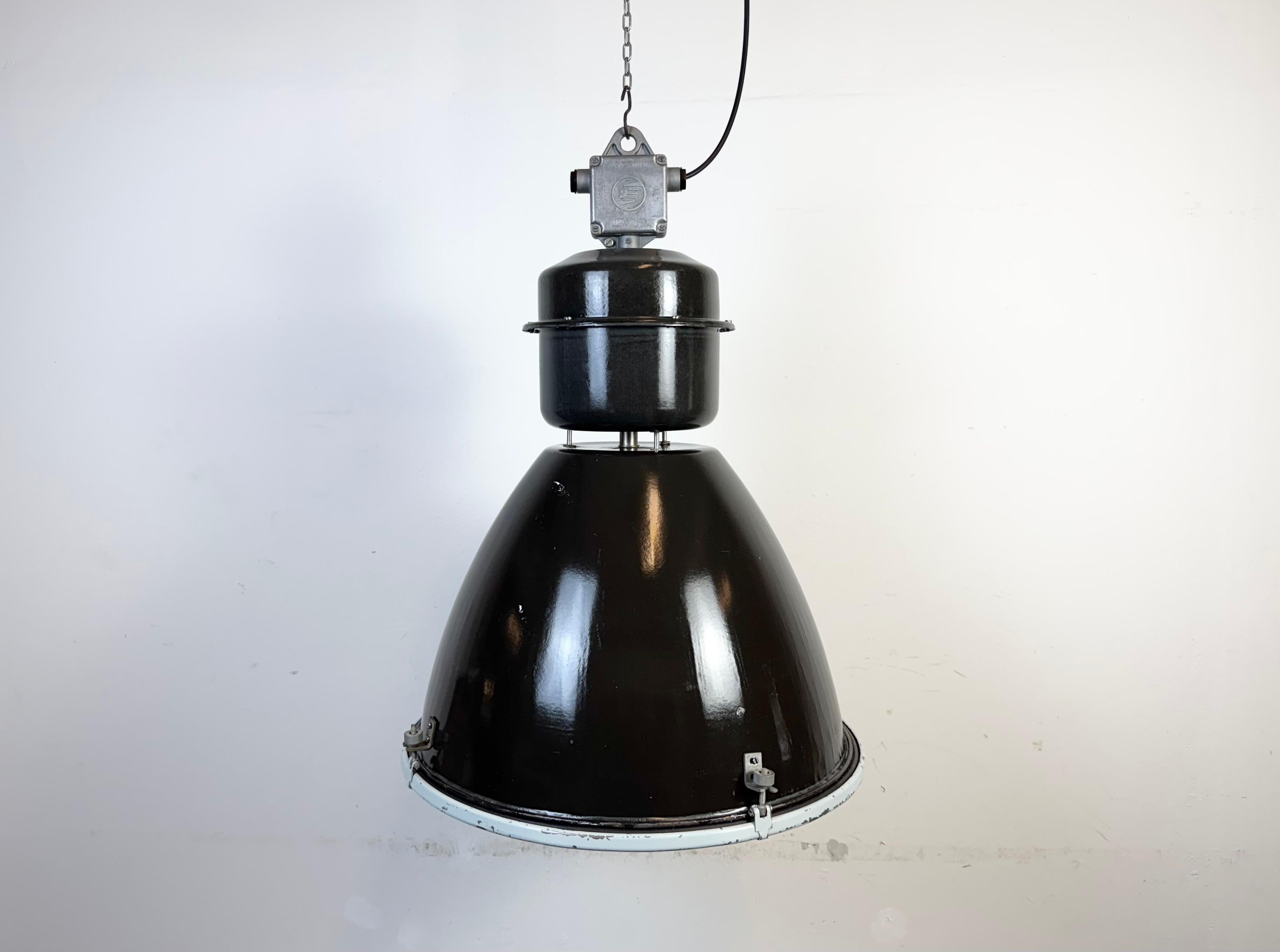 This large black industrial factory pendant light was designed and produced by Elektrosvit in former Czechoslovakia during the 1960s.It features a cast aluminium top, a black enamel exterior, a white enamel interior and clear glass cover.
New