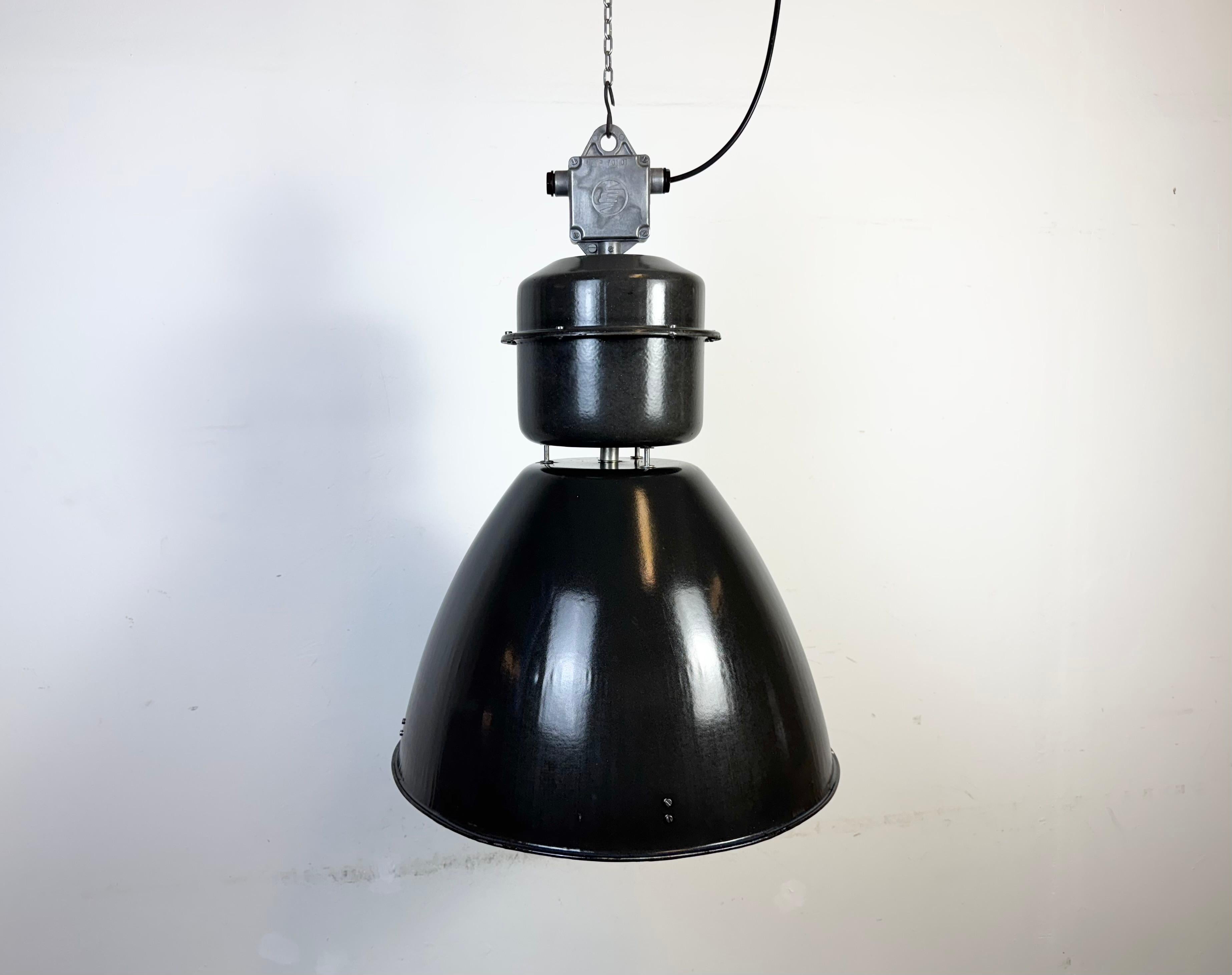 This large black industrial factory pendant light was designed and produced by Elektrosvit in former Czechoslovakia during the 1960s.It features a cast aluminium top, a black enamel exterior and a white enamel interior.
New porcelain socket requires