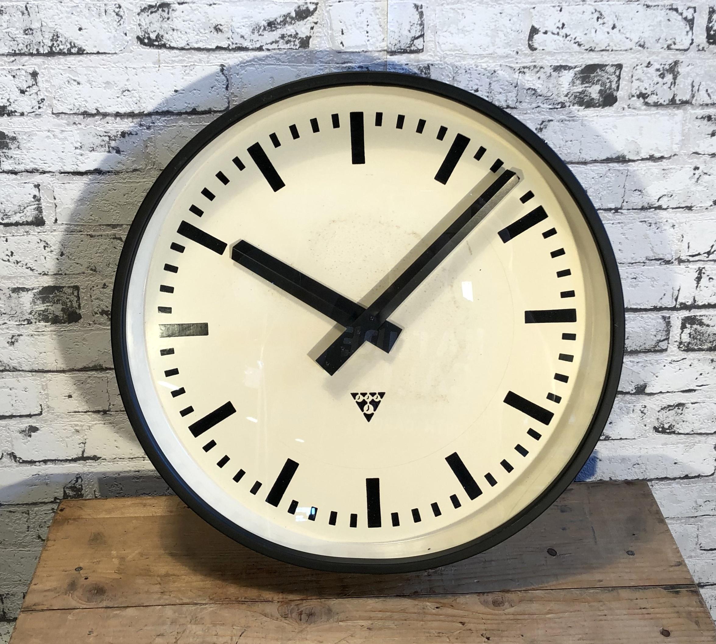 Pragotron wall clock made in former Czechoslovakia during the 1960s. It Features a black metal frame, metal dial and clear glass cover. The piece has been converted into a battery-powered clockwork and requires only one AA-battery. Measure: Diameter