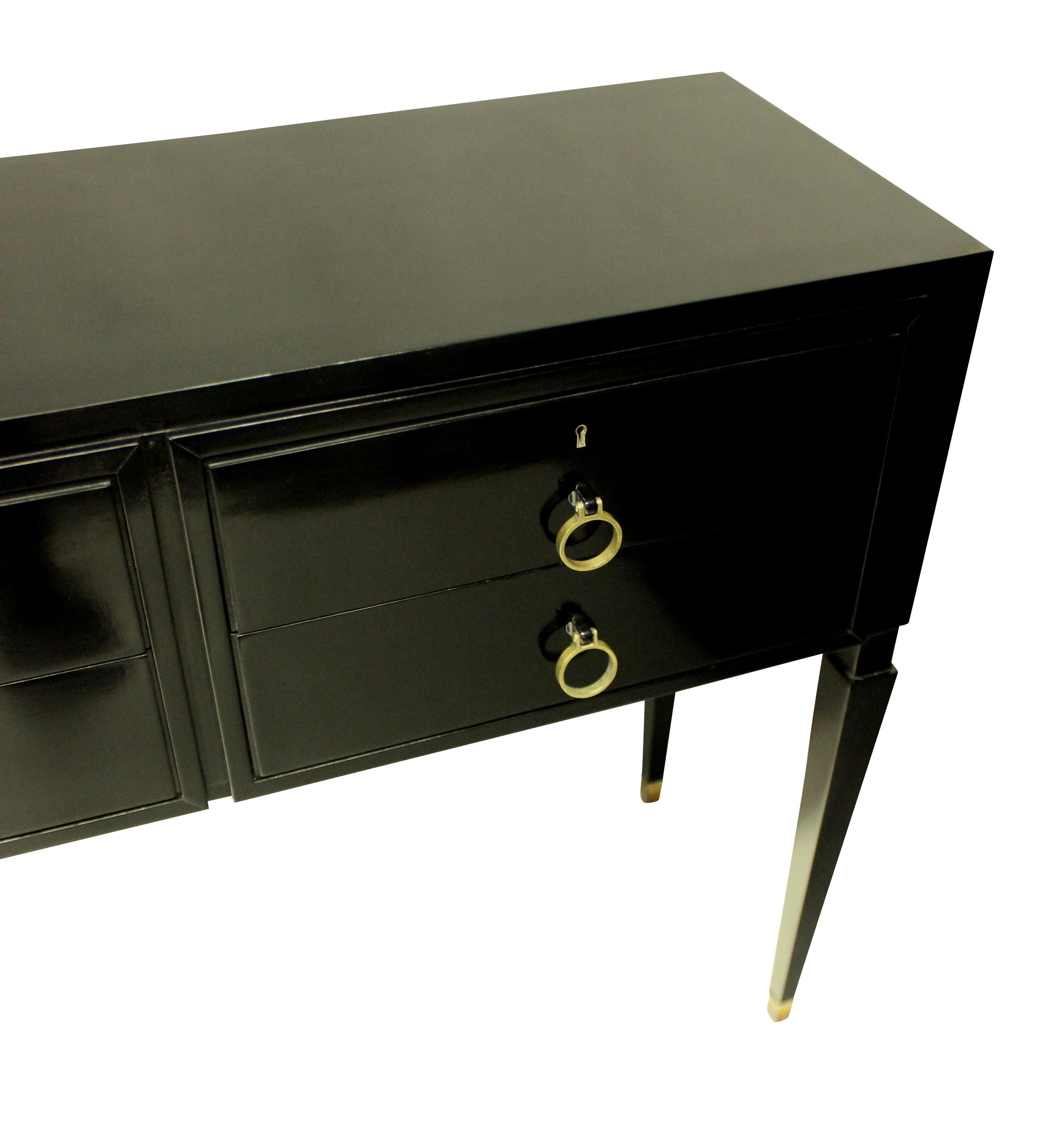A large Italian black lacquered six drawer console table in the Neo-Classical taste, by Paolo Buffa. On slender tapering legs, with brass sabot and handles to each drawer.