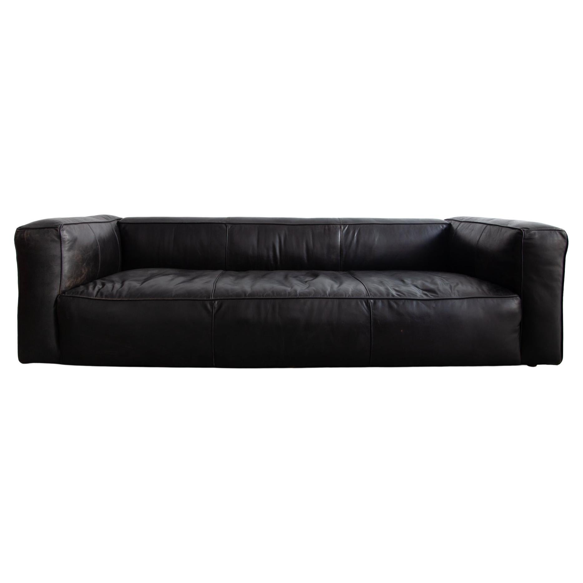 Large lounge leather comfortable sofa, daybed in black leather in original good condition with an architectural character. A sofa that could be set out in the middle of the room the geometrical lines of the exterior goes nicely with the soft bulky