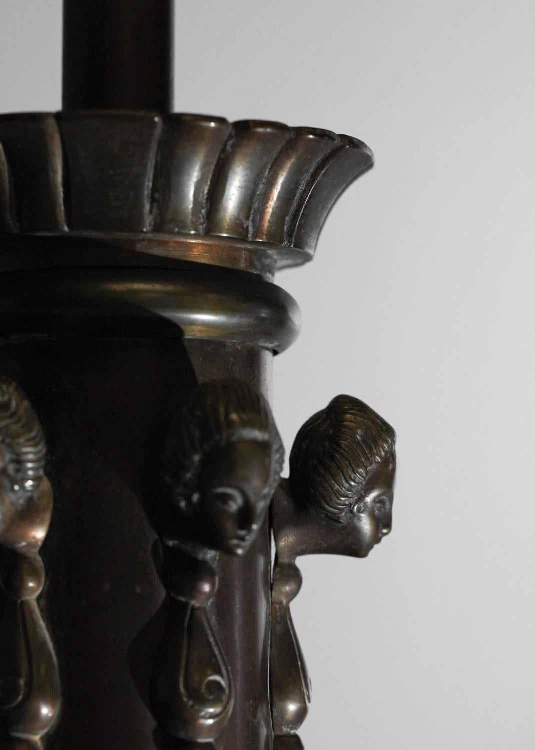 French bronze chandelier from the 30s/40s. Solid bronze structure with black patina, lampshade cups and frosted glass central disk. Superb detailing of the bronze work, with the central column decorated with women's heads. Very fine vintage