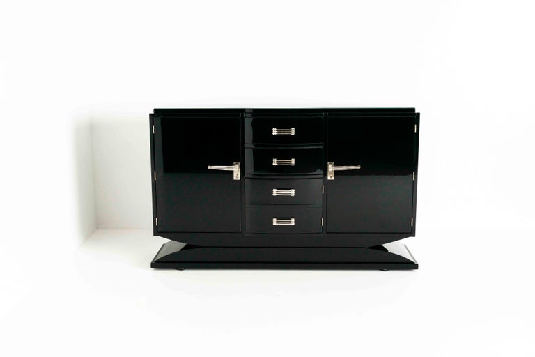 Large fully restored black piano-lacquered Art Deco cabinet from Germany, the 1930s. This cabinet has metal, chromed or nickel handles in a Bauhaus look and feel. On the left side is an entire glass compartment behind the doors, unfortunately, the