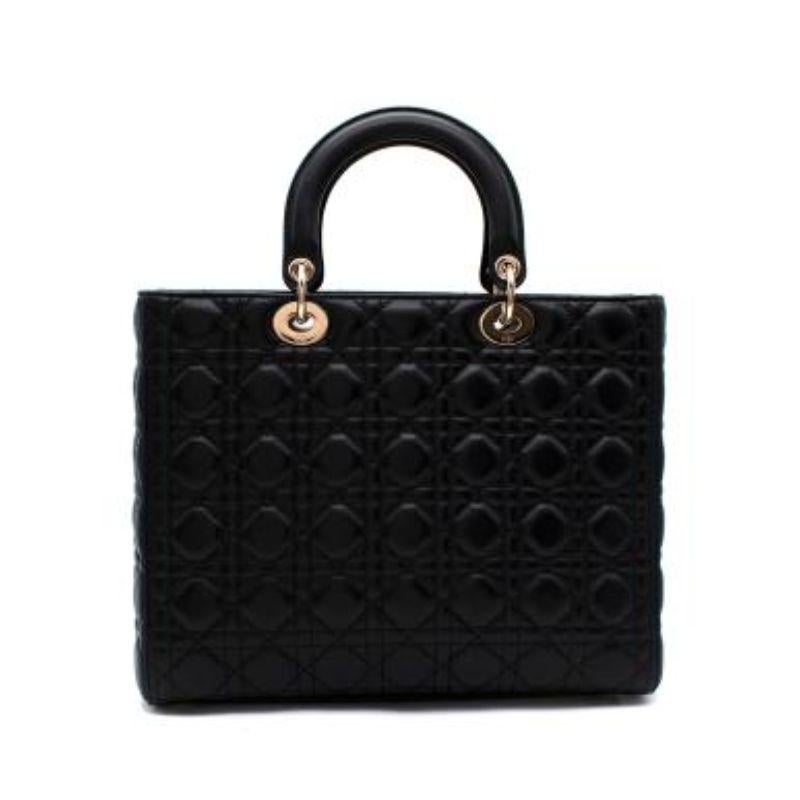 Dior Large Black Quilted Lady Dior Bag

- Boxy black leather tote with cannage stitching 
- Top handles with detachable long leather strap
- Gold hardware 
- Spell out logo charm
- Flat base with metal feet
- Internal flap closure 
- Suede interior