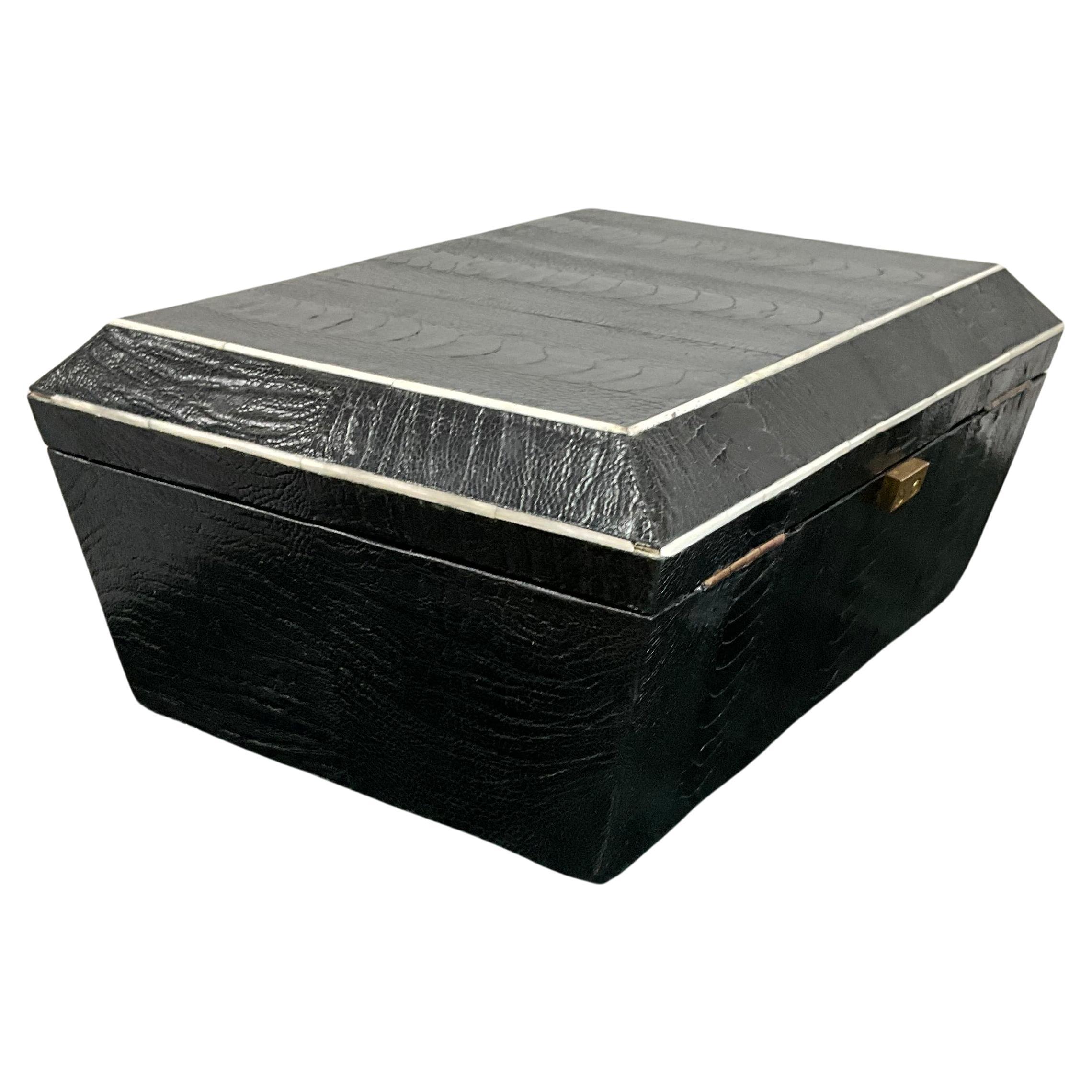Grande boîte en bois recouverte de peau de serpent, avec un plateau supérieur amovible à l'intérieur, qui convient pour les bijoux ou les petits souvenirs. L'intérieur est doublé de feutre noir et porte l'étiquette en laiton de R&Y Augousti sur la