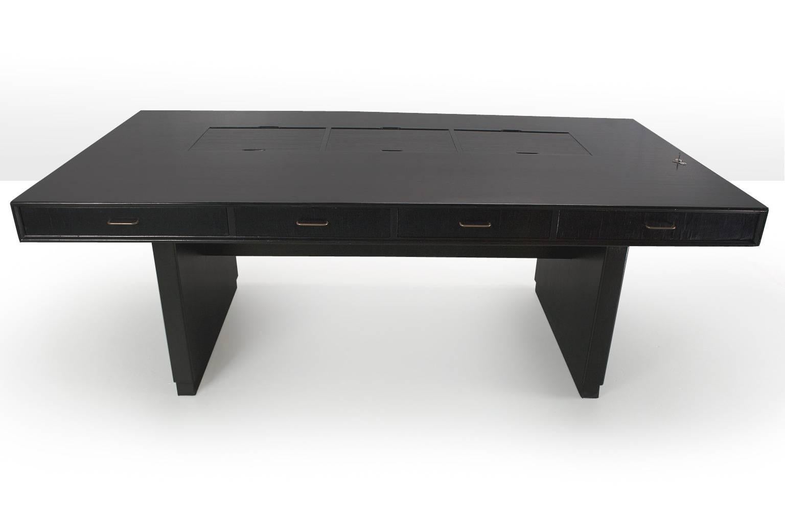 Very large, brutalist, free standing Tambour desk in black by Norwegian designers Clausen & Maerus , 1960s. This Scandinavian Modern sober, yet because of the size and the color, eye catching desk has four drawers on one side and three open storage