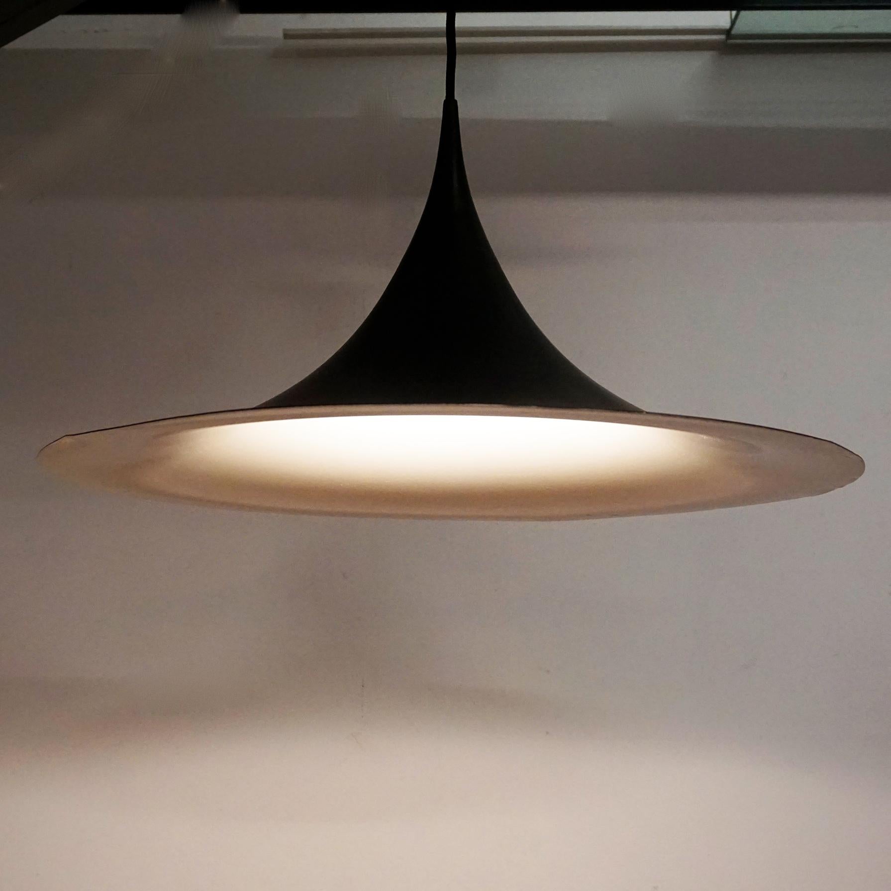 Large black lacquered Semi pendant lamp with offwhite interior. 
It has been designed by Torsten Thorup and Claus Bonderup in Denmark, 1960s and produced by Fog and Morup. Very rarely found in this size.
The Semi is one of the most iconic