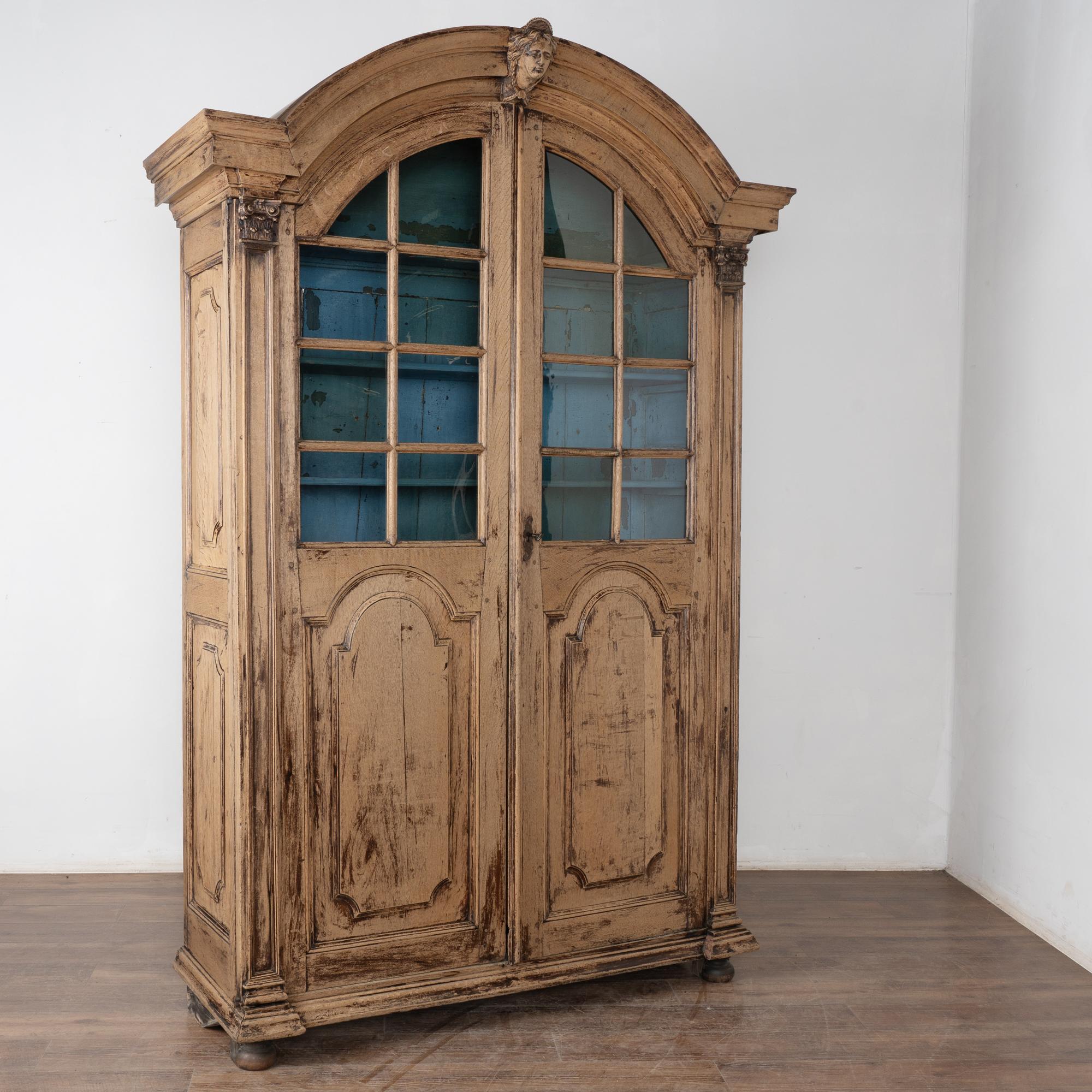 Cette grande bibliothèque ou vitrine en chêne blanchi est dotée d'un lourd capuchon incurvé, de portes vitrées supérieures et mesure plus de 8 pieds de haut.
Idéale pour présenter des livres ou toute autre collection, elle comporte quatre étagères