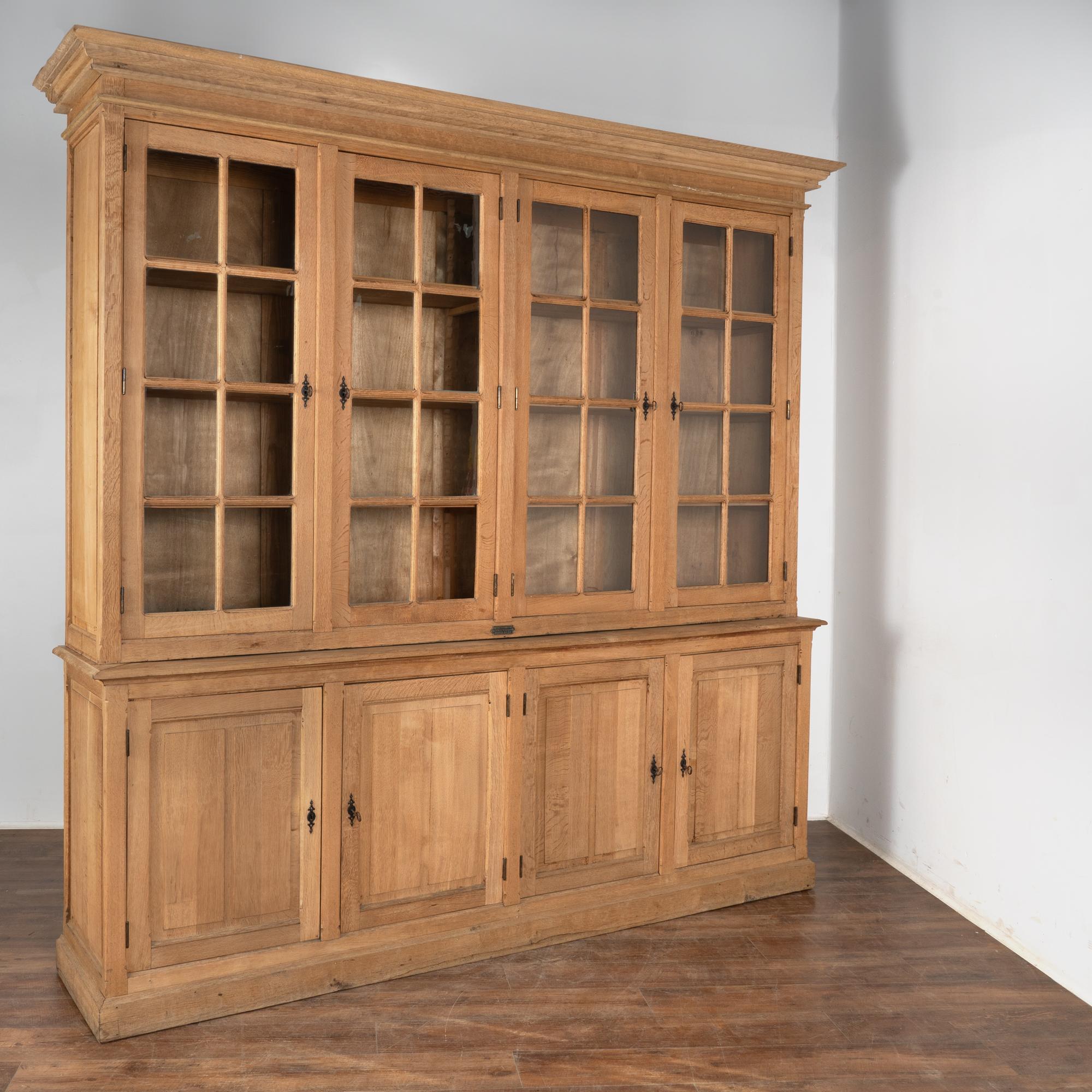 This impressive oak bookcase has four upper glass paneled cabinet doors and four panel cabinet doors below.
The oak has been bleached creating a fresh, lighter finish for today's modern home.
This large display cabinet is made in two sections, upper