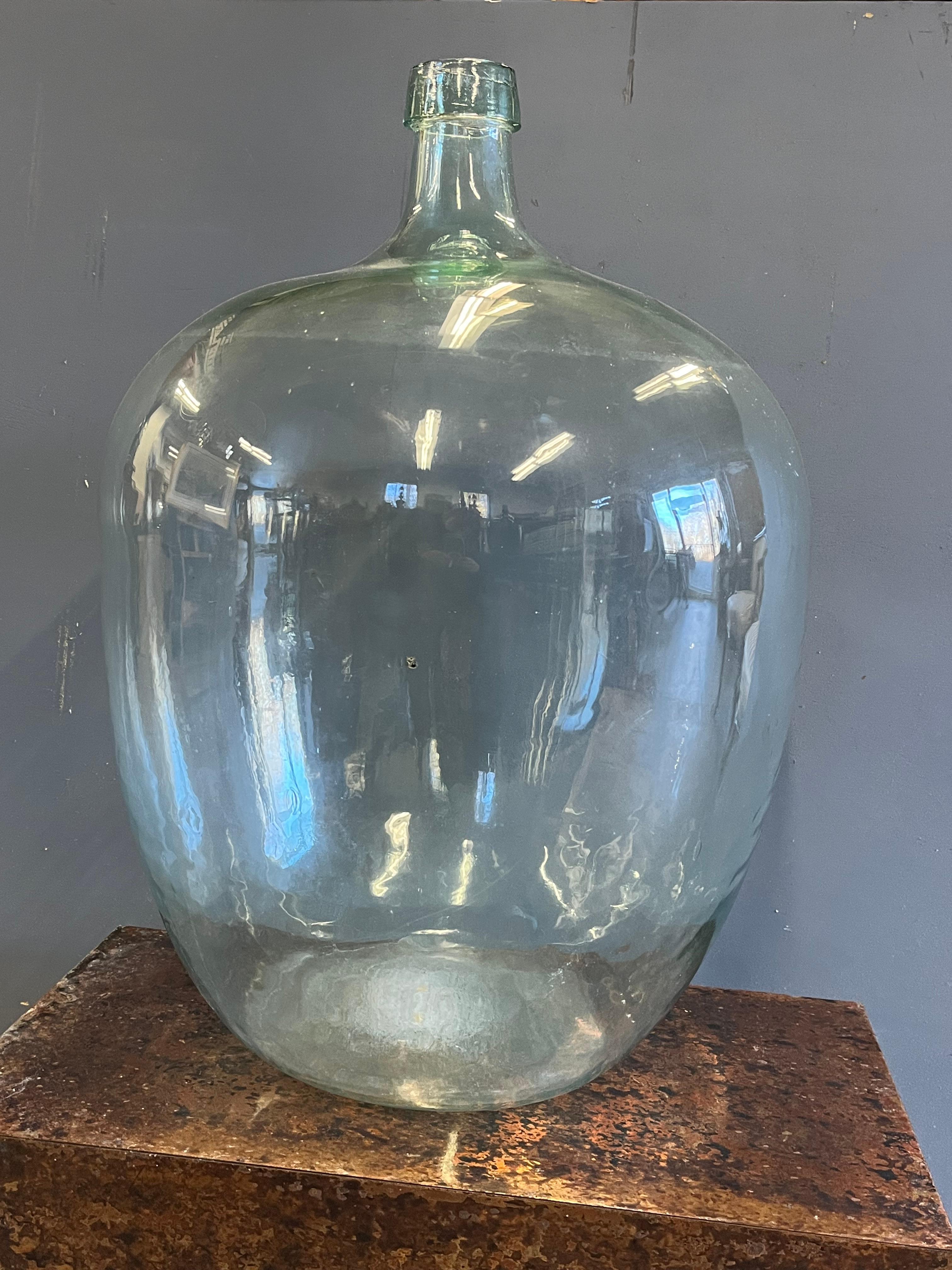 A large aqua blown glass demijohn with applied tooled lip circa 1870. 