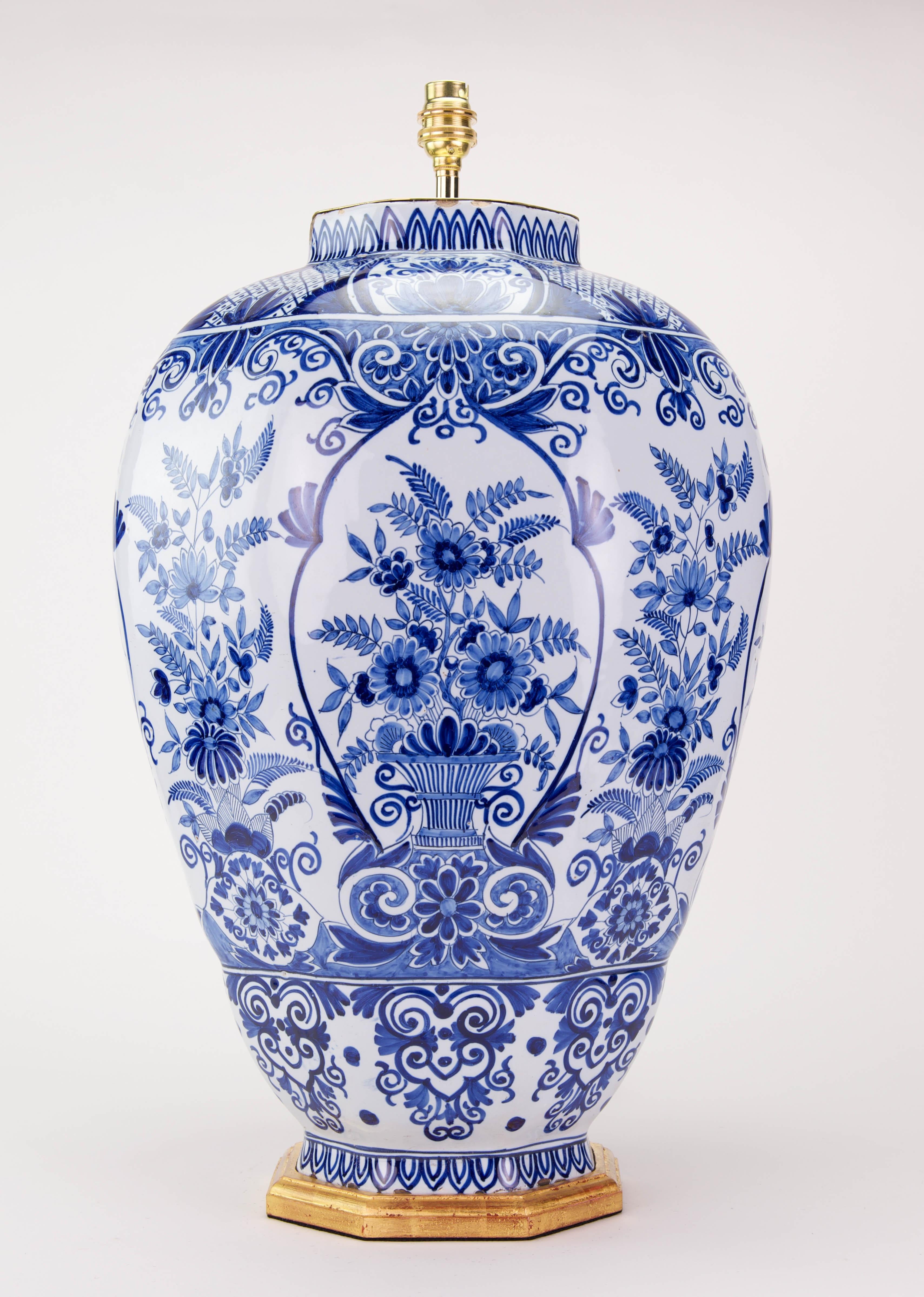 A fine large Dutch Delft blue and white vase, of hexagonal form, beautifully decorated trhoughout  in tones of blue on a white ground, with  foliage and flowers and further stylised motifs, now mounted as a lamp with a giltwood base.

Height of