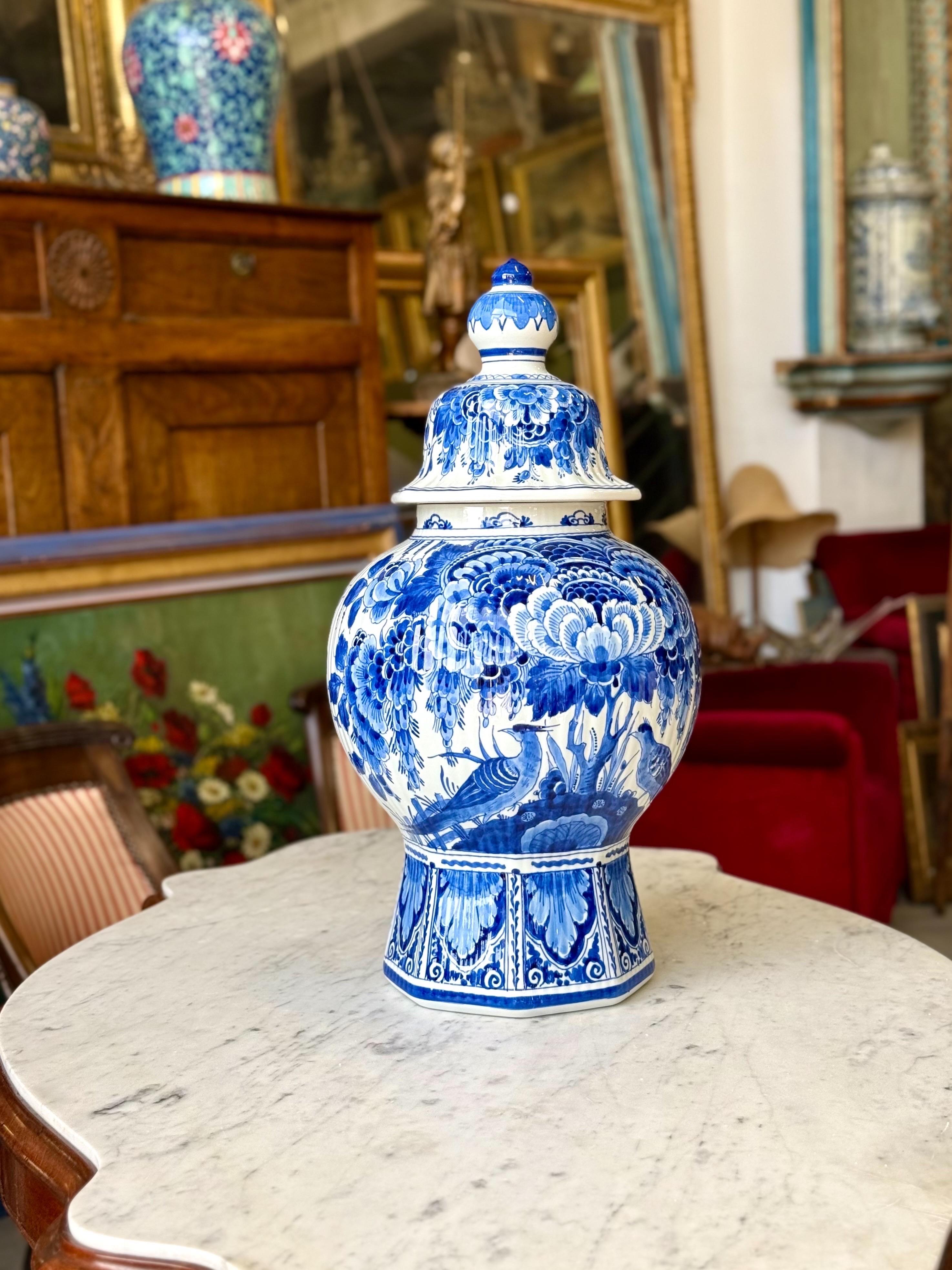 Questo straordinario vaso di maiolica rivestito è un ottimo esempio di ceramica di Delft, riccamente decorato in blu cobalto su fondo bianco. Il design dipinto a mano presenta eleganti uccelli annidati tra grandi fiori e fogliame a cascata,