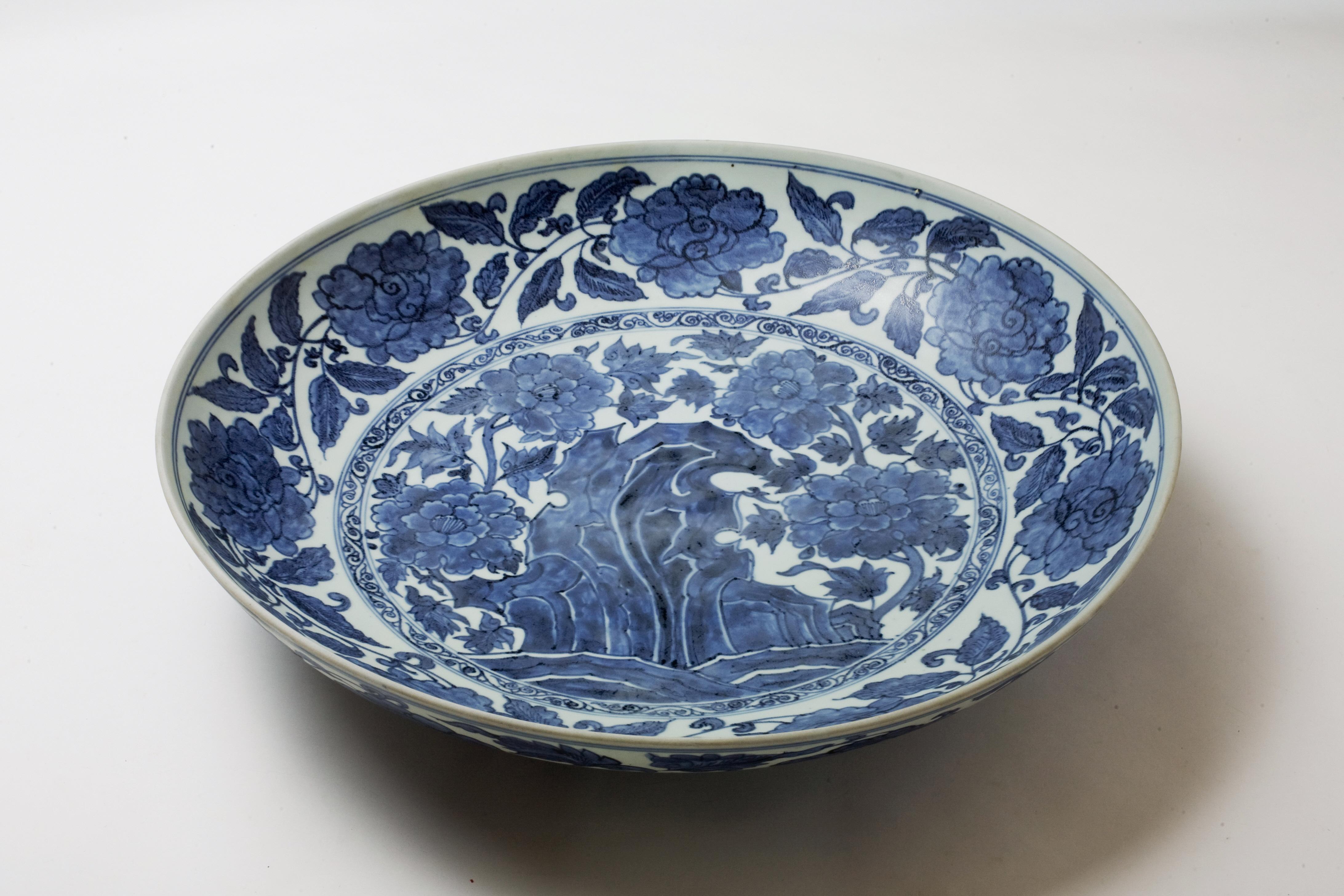 This dish features a rockwork design that was popular during the Mid to Late Ming dynasties. The blue-and-white underglaze effectively captures the vibrant tones typical of the late Ming and early Qing periods. The detailed depiction of flowers,