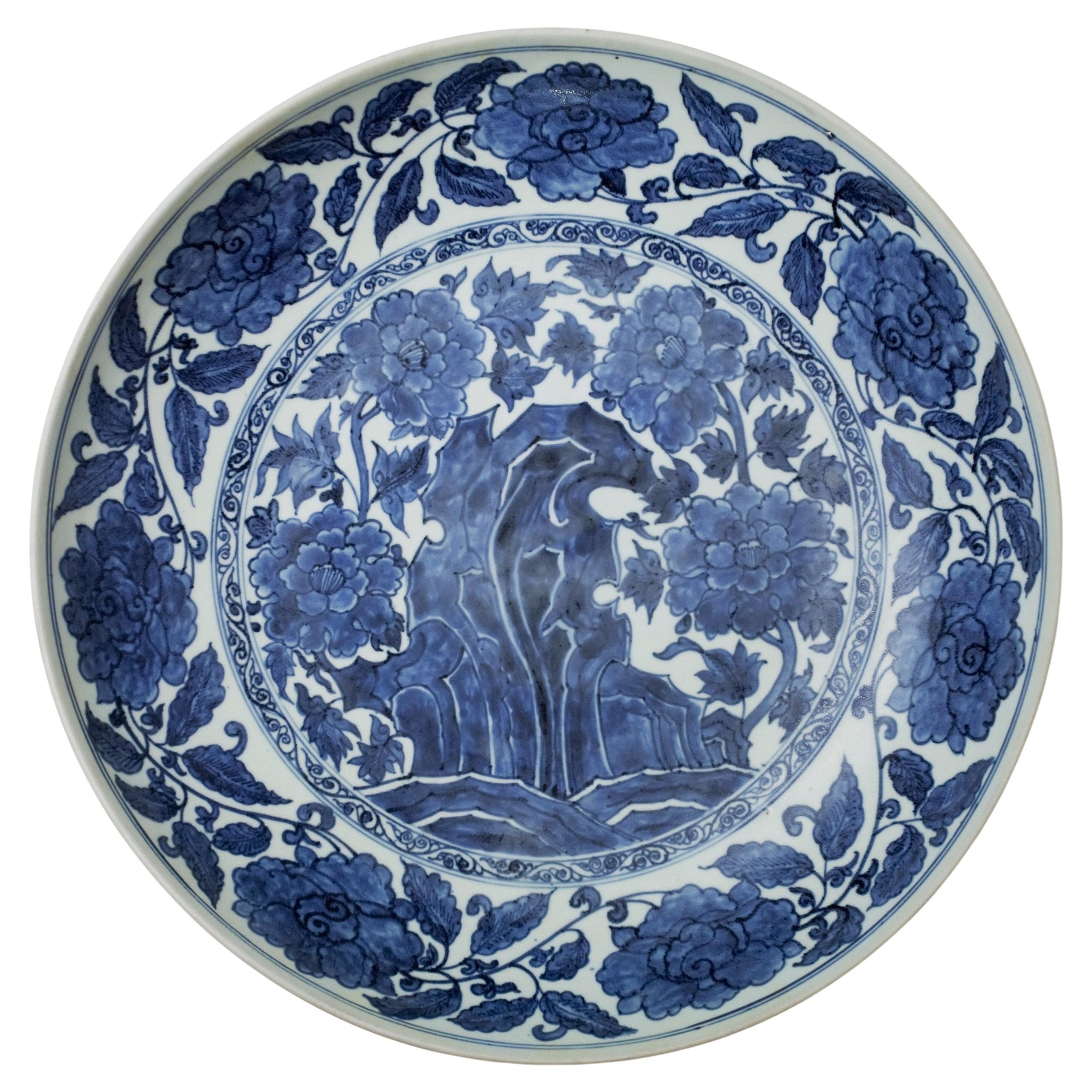 Grande piatto blu e bianco con "rocce e fiori", dinastia Qing
