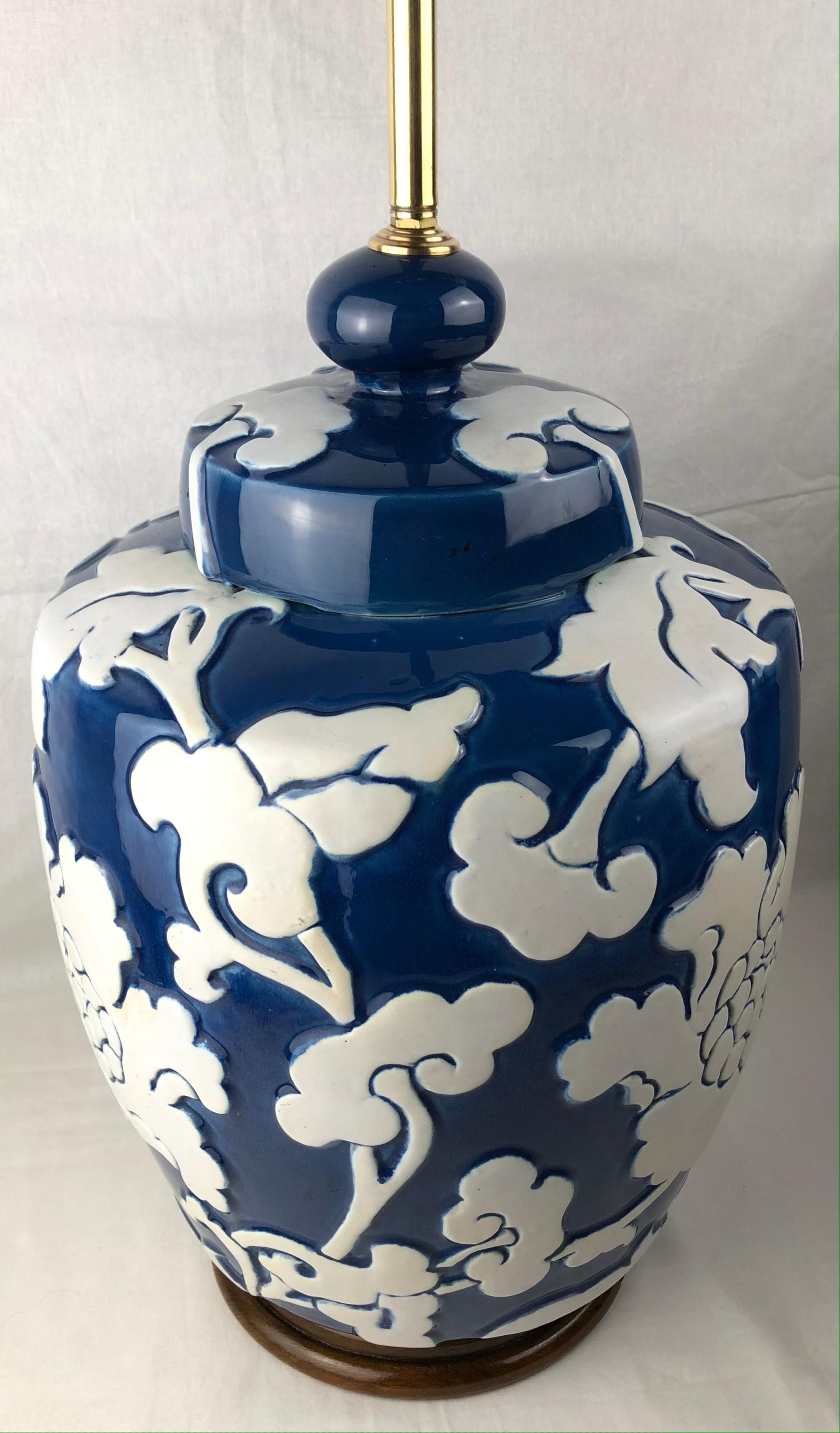 A circa 1920s French porcelain table lamp with floral motif on blue-glaze and a walnut wood base. High relief motifs. The provenance of this beautiful lamp is a prominent estate in St.-Remy-de-Provence. 

Measurements:
Height of body 38 1/2