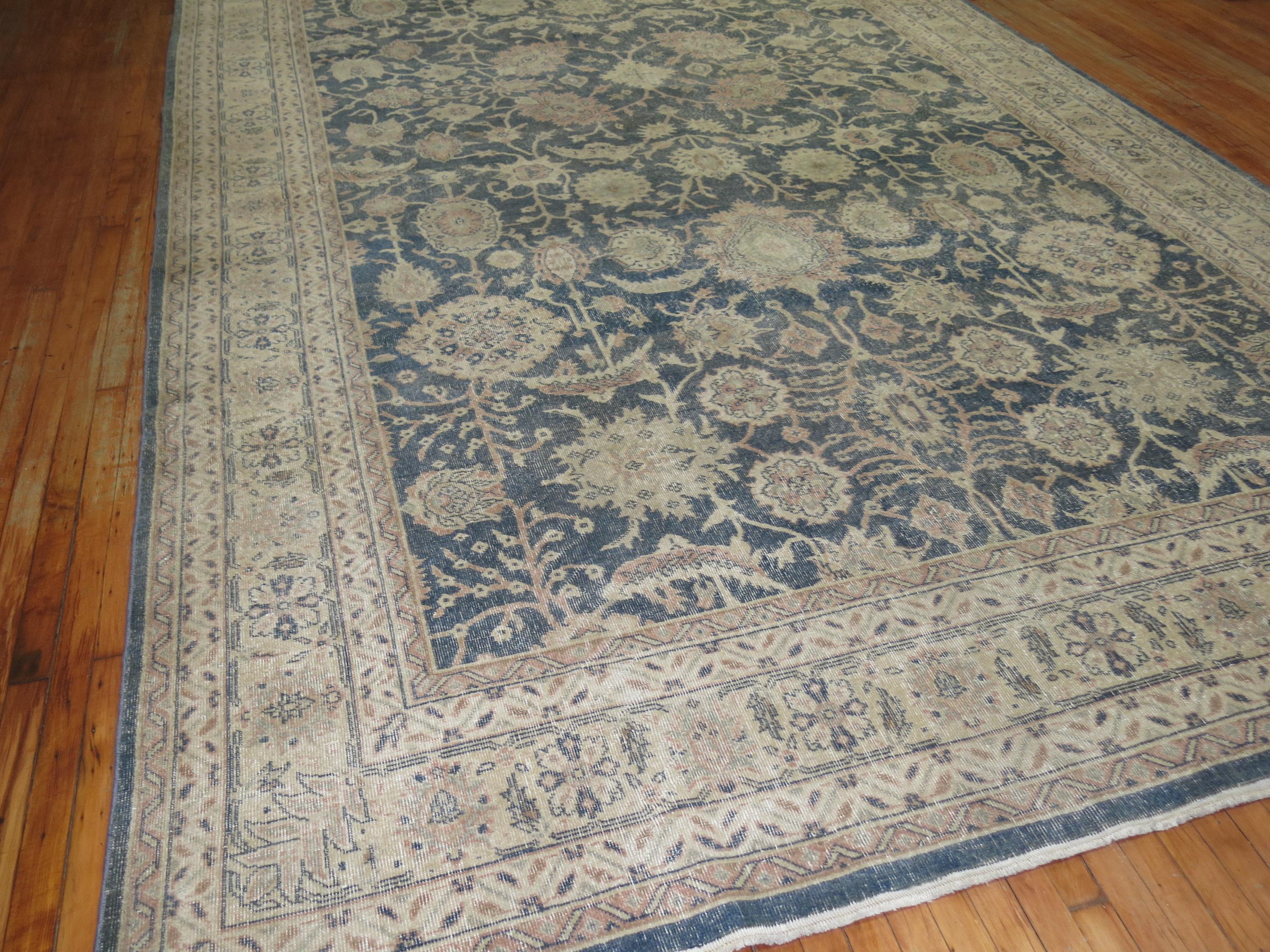 An evenly worn oversize mid-20th-century Turkish rug in predominant blue-gray, accents in peach.

Measures: 9'7
