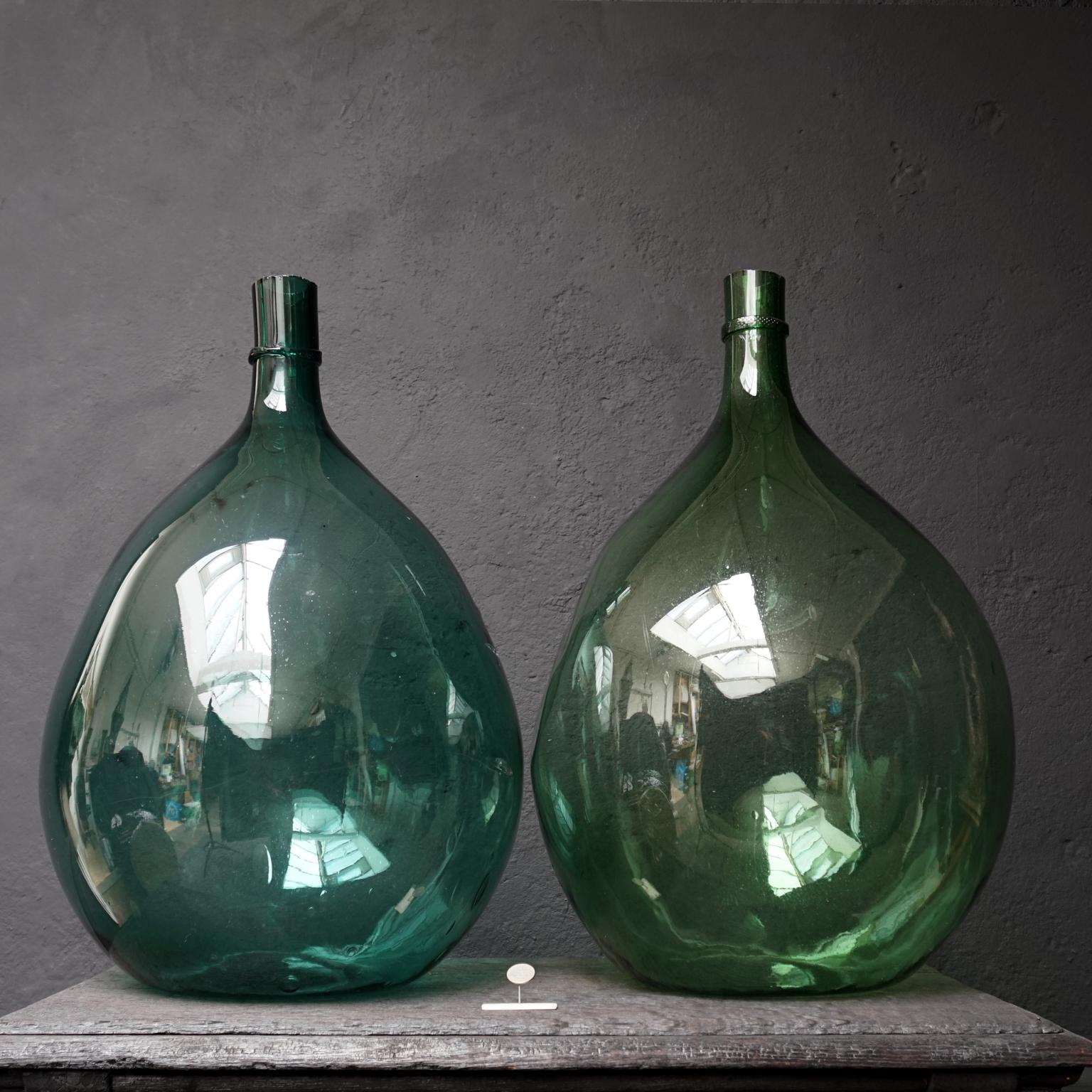 Hand blown in a globular or large ballon form with hand added bottlenecks and cut rim
Wonderful shade of blue-ish green, hand blown wine bottle, also known as Dame Jeanne, Demijohn, Carboy or Bonbonne bottle with a very nice 'dent' in the