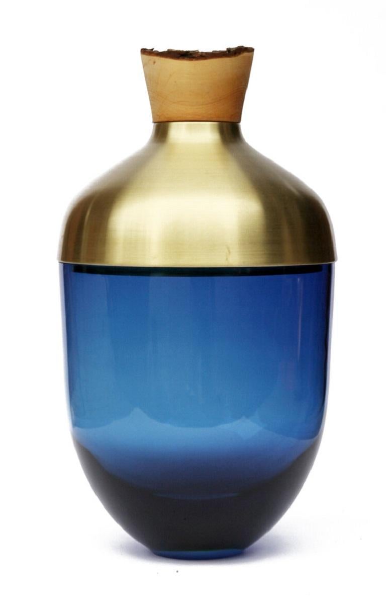 Large blue India vessel I, Pia Wüstenberg
Dimensions: D 30 x H 55
Materials: glass, wood, metal
Available in other metals: brass, copper

Handmade in Europe, by individual craftsmen: handblown glass (Czech Republic), hand spun metal, (England),